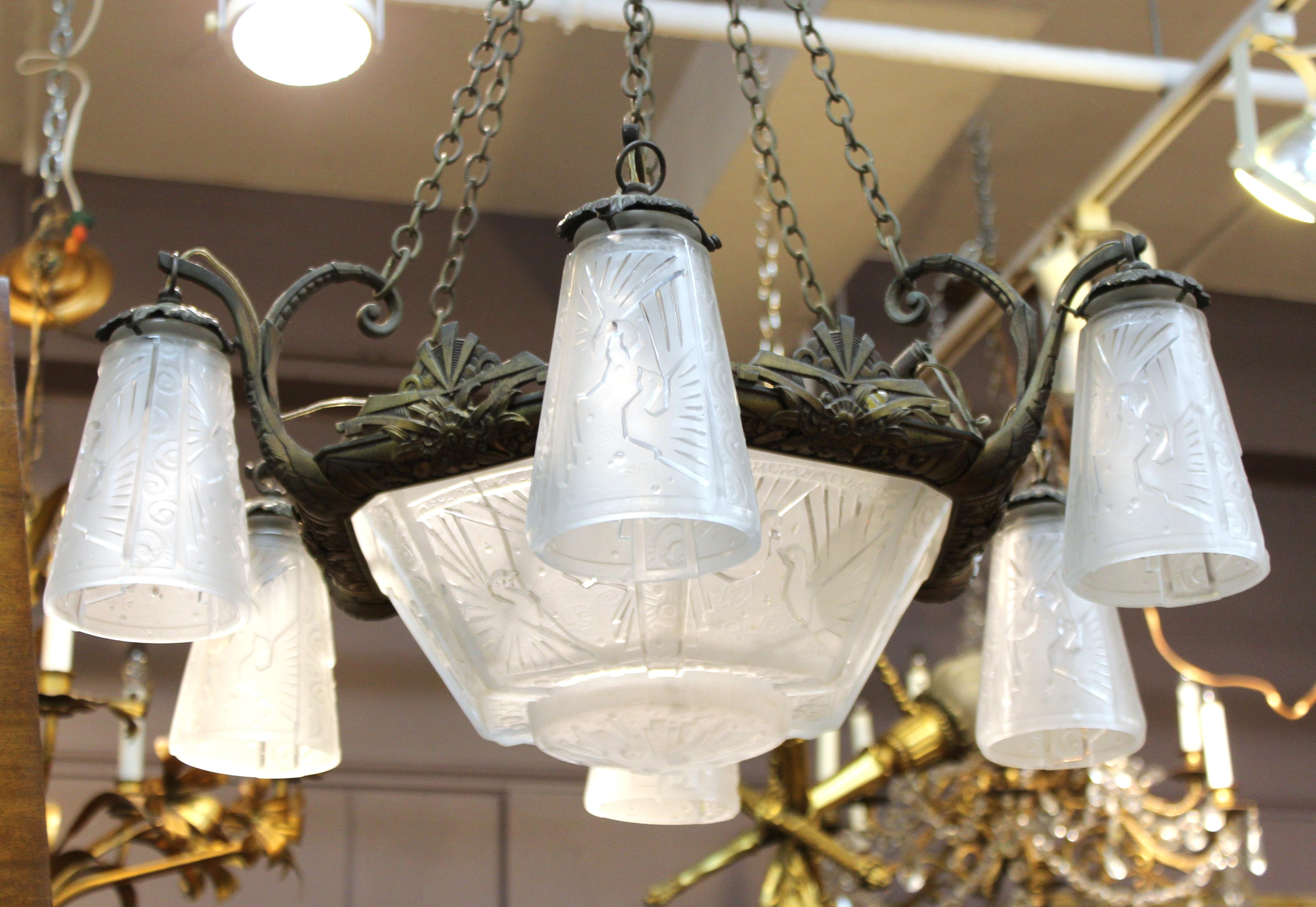 French Art Deco period ceiling chandelier designed by Muller Freres in Luneville, France. The very thick white molded glass shades are decorated with birds in flight and swirl patterns. There are a couple of minor chips to the edges of the glass