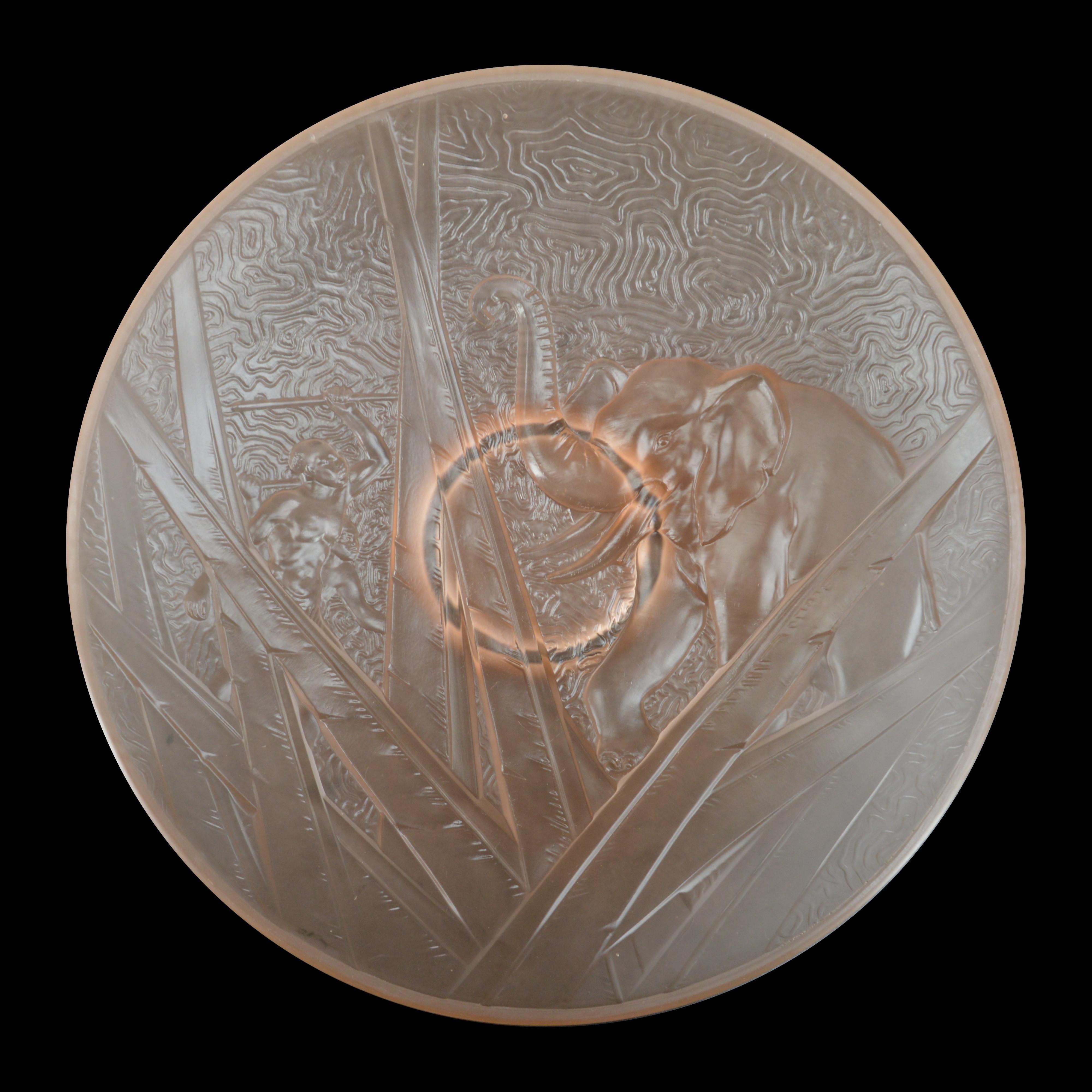 Coupe centrale Art Déco de MULLER FRERES (Luneville), France, années 1920. Deux chasseurs africains contre un éléphant. Bol en verre moulé et pressé rose/pêche. Diamètre : 13.8