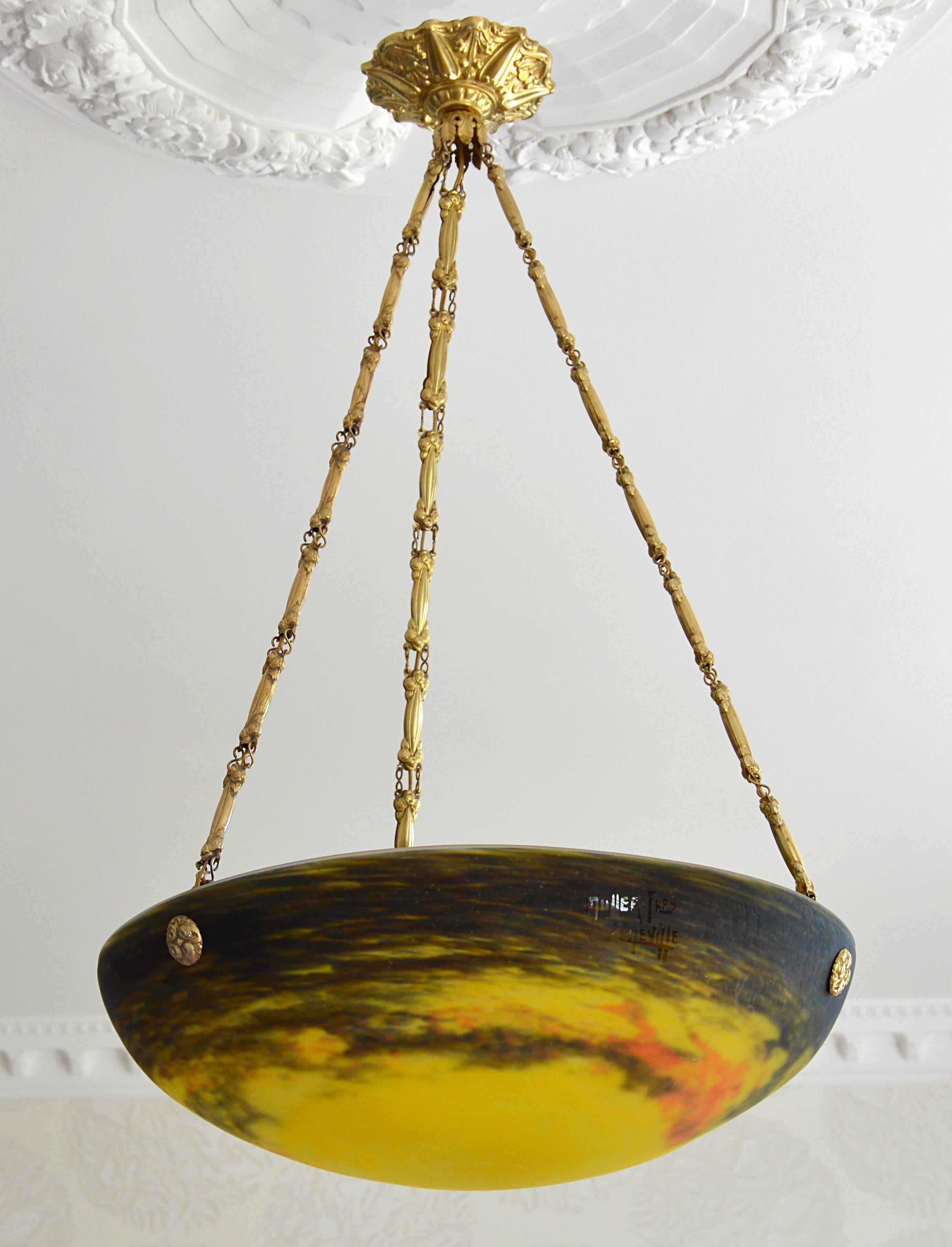 French Art Deco pendant by Muller Frères, Luneville, France, circa 1925. Mottled glass shade, powders are applied between two layers, that comes hung at its original brass fixture. Measure: Height 26