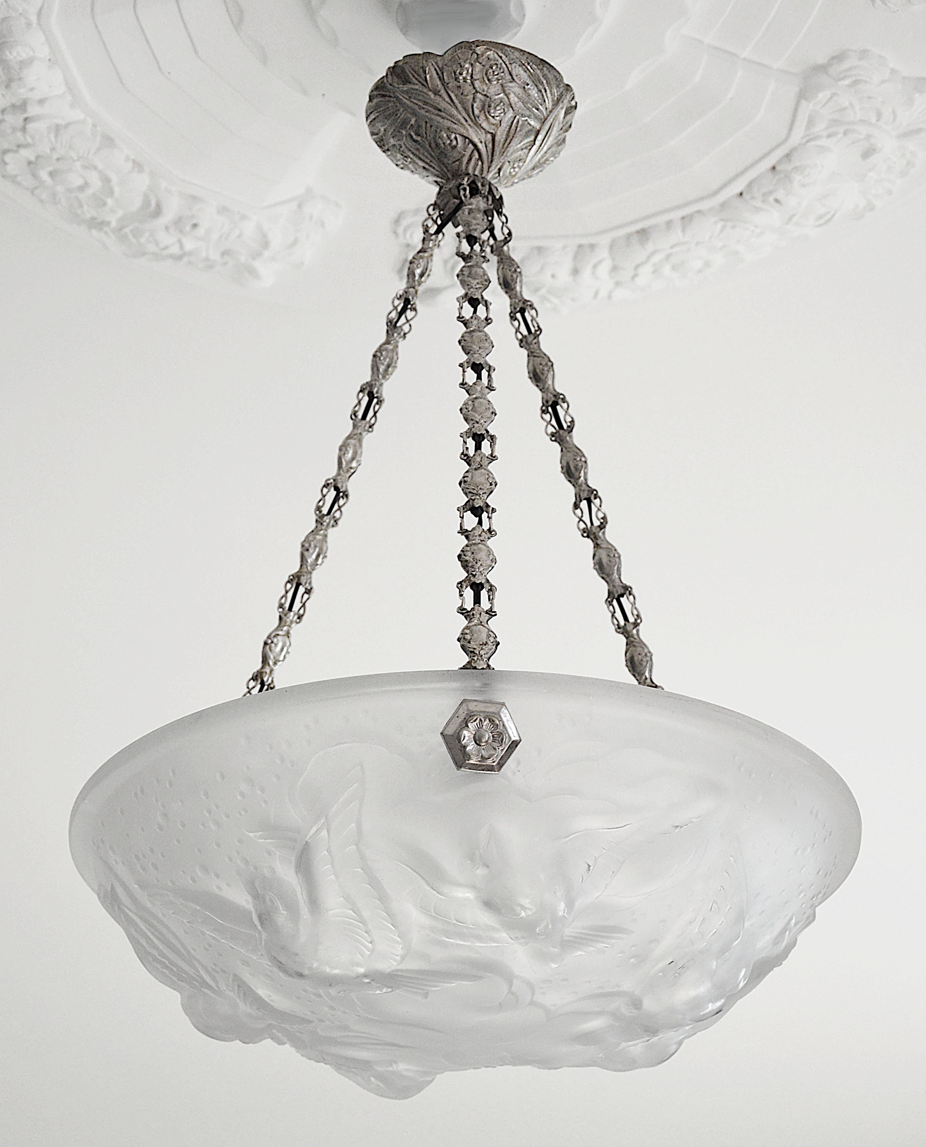 French Art Deco pendant chandelier by Muller Freres (Luneville), France, 1920s. White frosted molded-pressed glass shade showing 6 swallows in the sky. It comes with its nice period silverplated bronze and stamped brass (links) fixture. Height