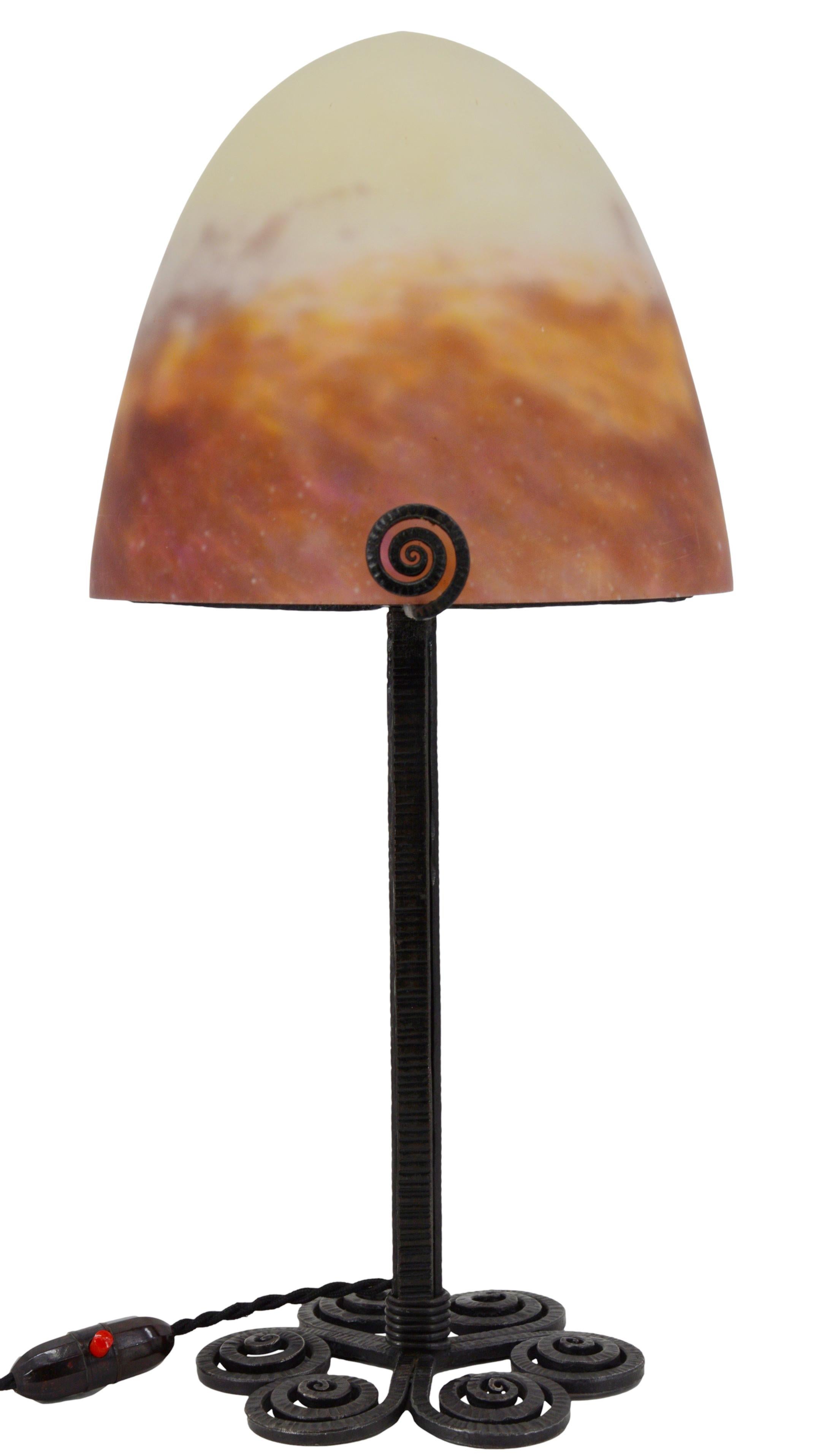 French Art Deco table lamp by Muller Frères, Luneville, France, circa 1925. Mottled glass shade, powders are applied between two layers, cut with the tool, that comes on its classy wrought iron base. Colors: purple, old rose and pale yellow. The top