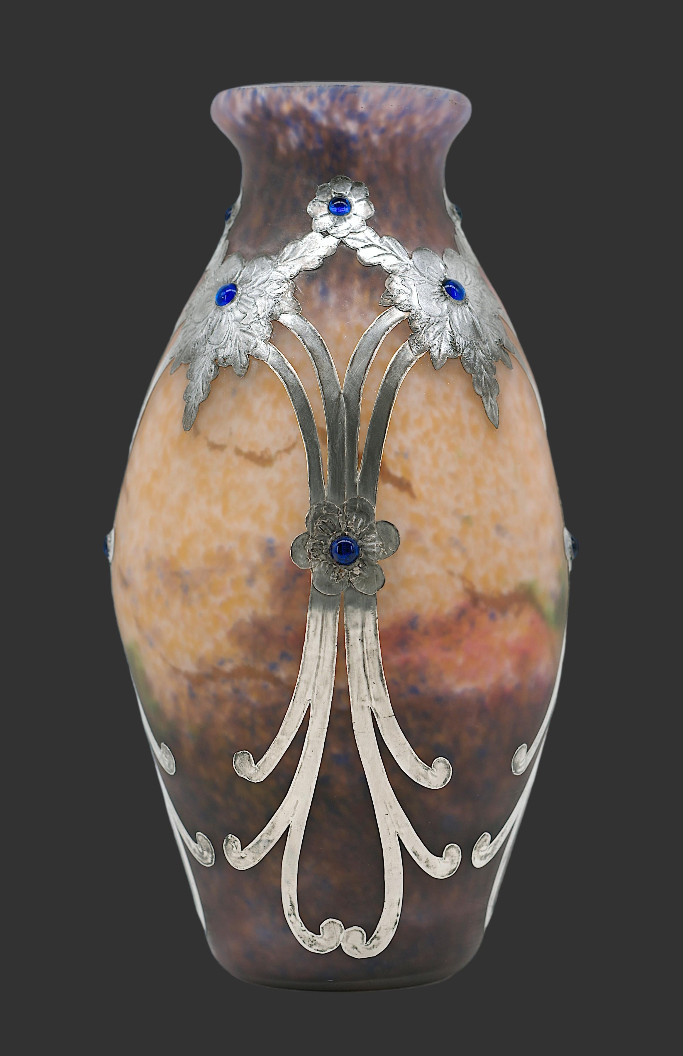 Vaso francese Art Deco di MULLER FRERES, Luneville, Francia, 1920 circa. Raro vaso in vetro a doppia screziatura, con polveri blu, verdi, rosa e bianche applicate tra i due strati. Decorato con fiori stilizzati in peltro con cabochon in vetro blu.
