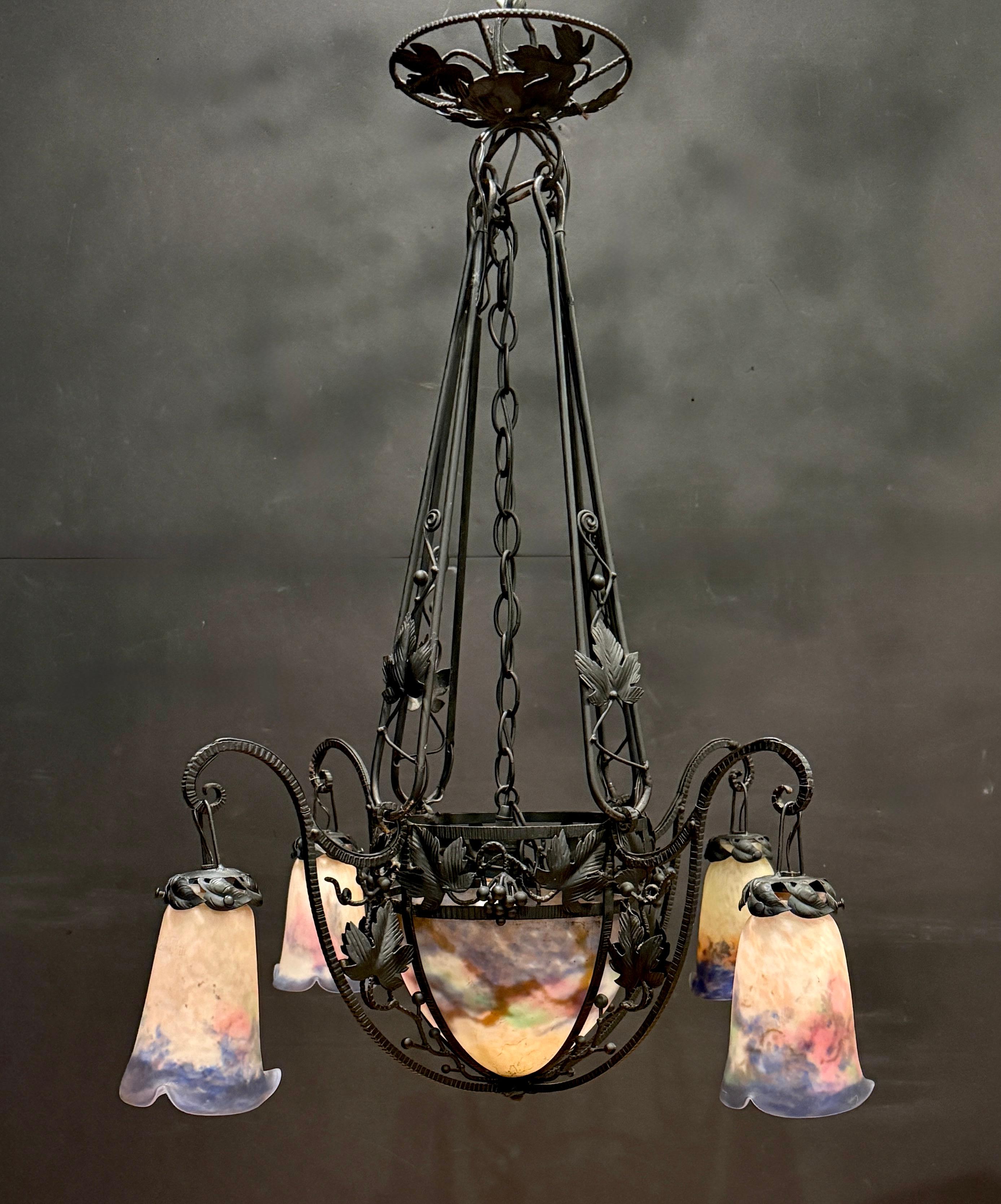 Excepcional araña Art Nouveau de Luneville firmada por Muller Fr�ères, con un marco de hierro forjado magistralmente forjado a mano y adornado con motivos naturalistas de vides y hojas. La luminaria soporta cuatro brazos elegantemente curvados y un