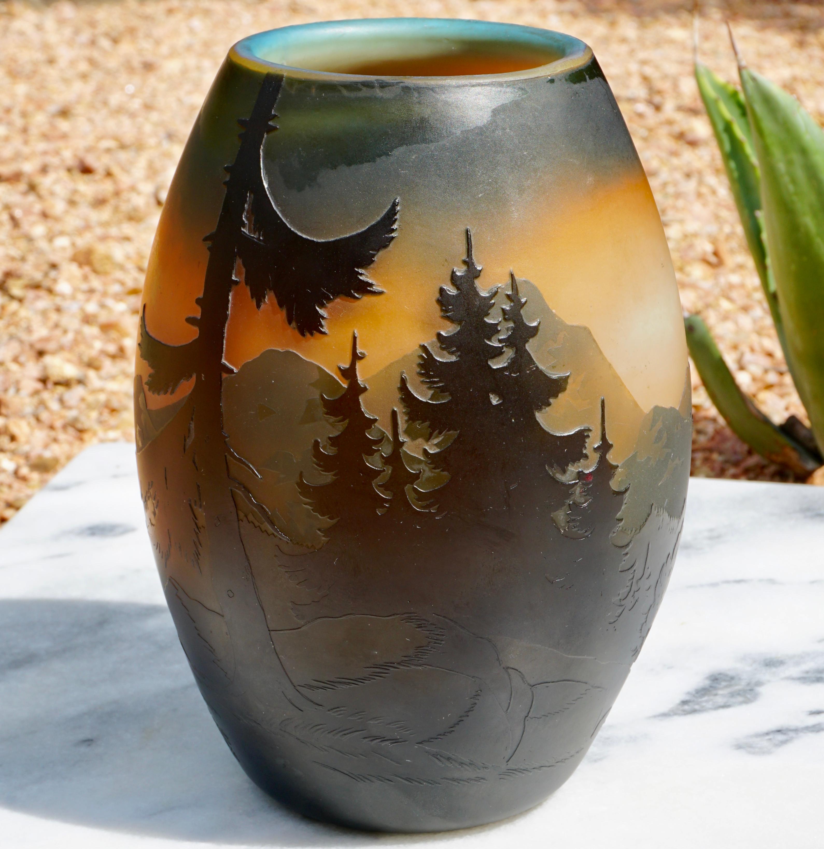 Muller Frères Luneville cameo mountain landscape vase, circa 1915. Art Nouveau - Art Deco cameo art glass wheel carved and acid etched vase with layers of evergreens and mountains in the background.

Measures: Height 7.75 inches
Diameter 5.25