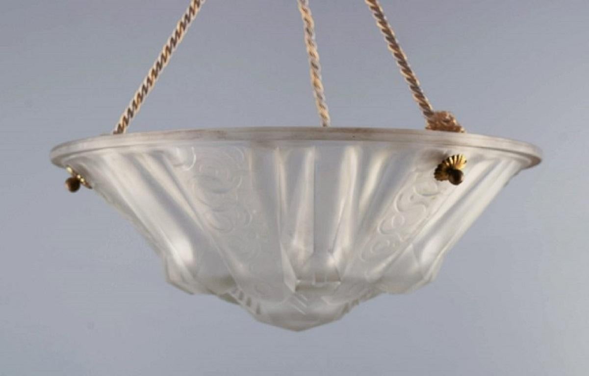 Muller Frères, Luneville. Grand lustre Art Déco impressionnant avec feuillage en verre d'art dépoli.
Années 30/40.
Écran en verre mesurant : D 35,0 cm. x H 14,0 cm.
Hauteur totale, suspension comprise, 55,0 cm.
En parfait état.
Signé.