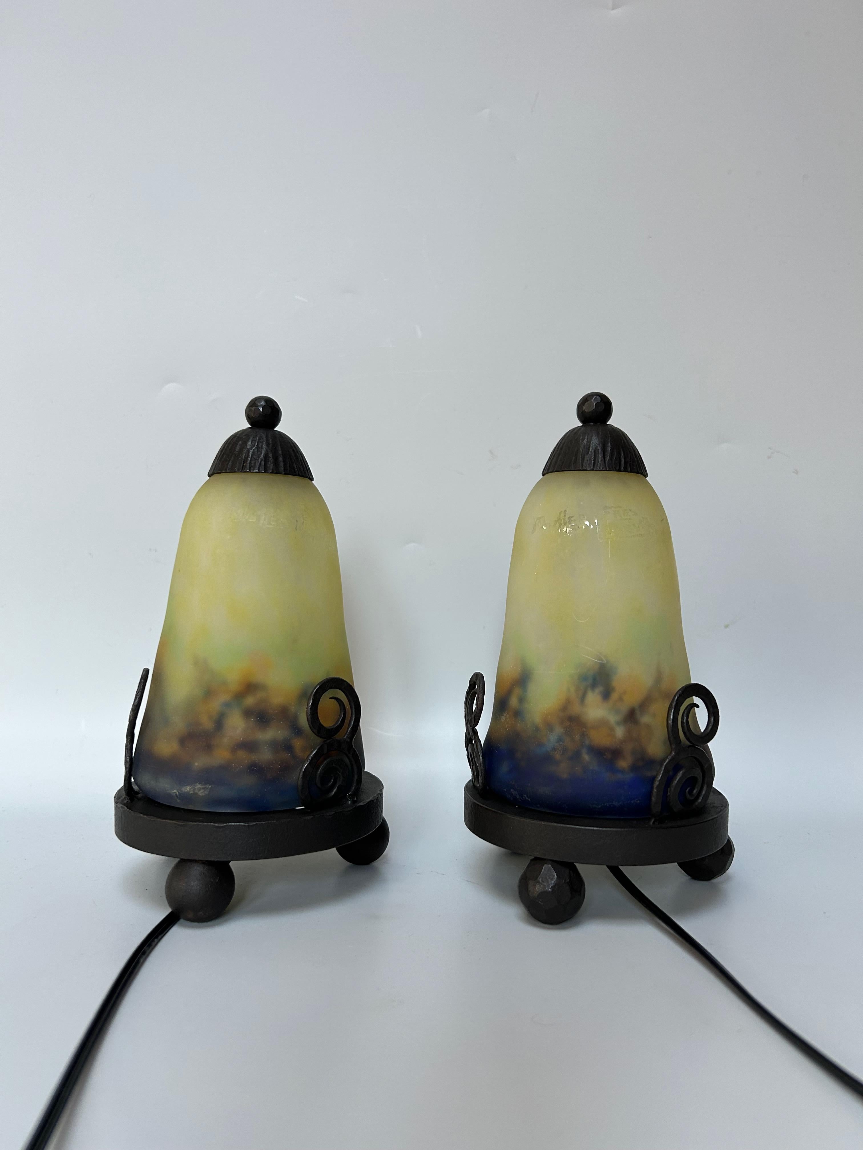 Paire de veilleuses art déco circa 1925.
Cadre en fer forgé.
Tulipes en pot en verre signées Muller Frères.
En parfait état et électrifié.

Hauteur totale : 20.5 cm
Diamètre : 11 cm

Les frères Muller, fondateurs de la verrerie Muller Frères à