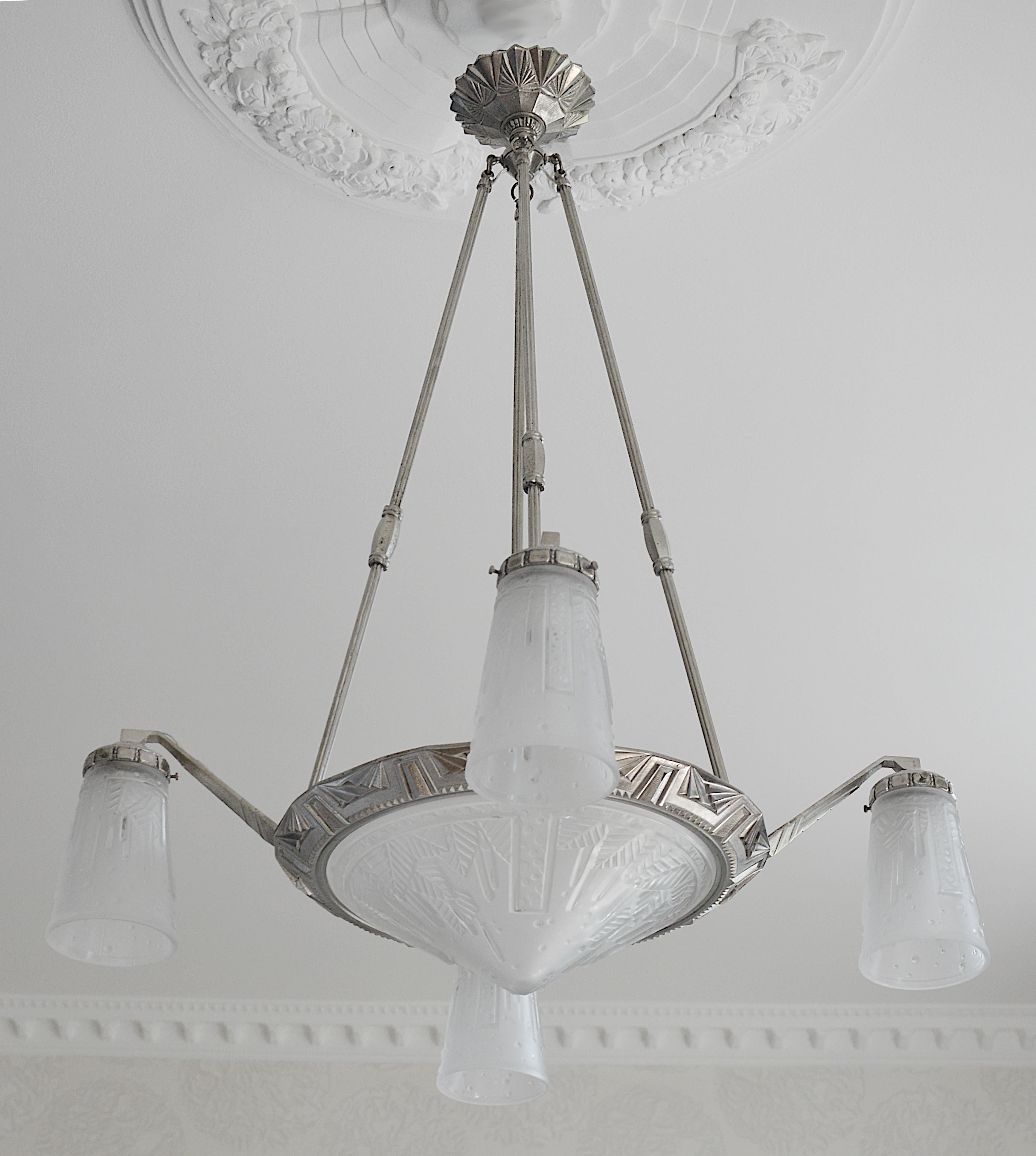 Lustre Art déco français par Muller Frères (Luneville) et Pierre Maynadier (Paris), France, vers 1925. Verre et bronze. D'épais abat-jour en verre dépoli sont suspendus à leur luminaire en bronze nickelé. Hauteur : 32