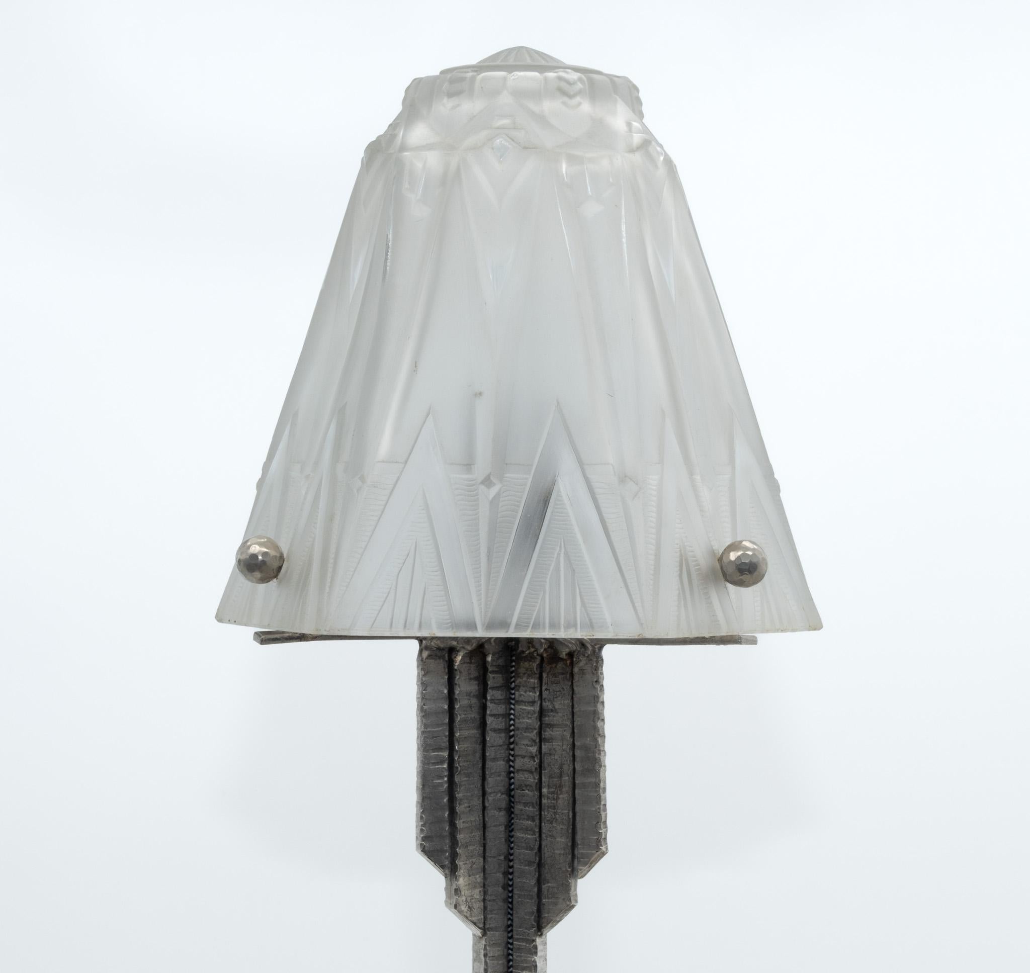 Art Deco silvered iron table lamp by Muller Frères in the Edgar Brandt manner. French. Circa 1930. Signed.

Produced by the famous Muller Frères of Luneville, the lamp shows strong Art Deco design, the frosted shade being of a hexagonal section
