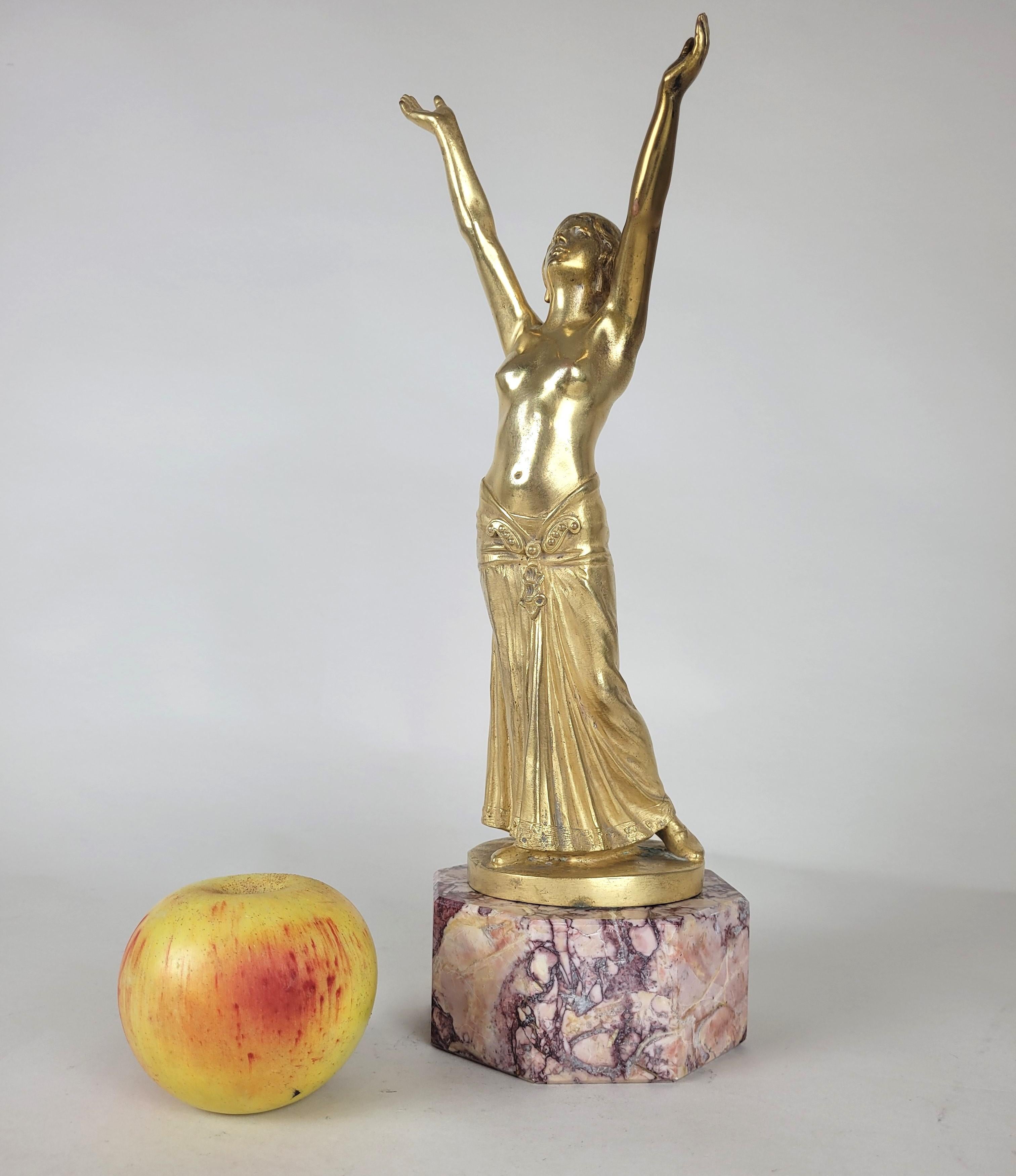 Priestess in gilded bronze, arms raised to the sky, dressed in a beautiful draped dress and jewelry, on a marble base in pink tones

This sculpture is signed Ch Muller and numbered n°2

Usual wear to the gilding

Height 34 cm
11 x 11cm

Art Nouveau