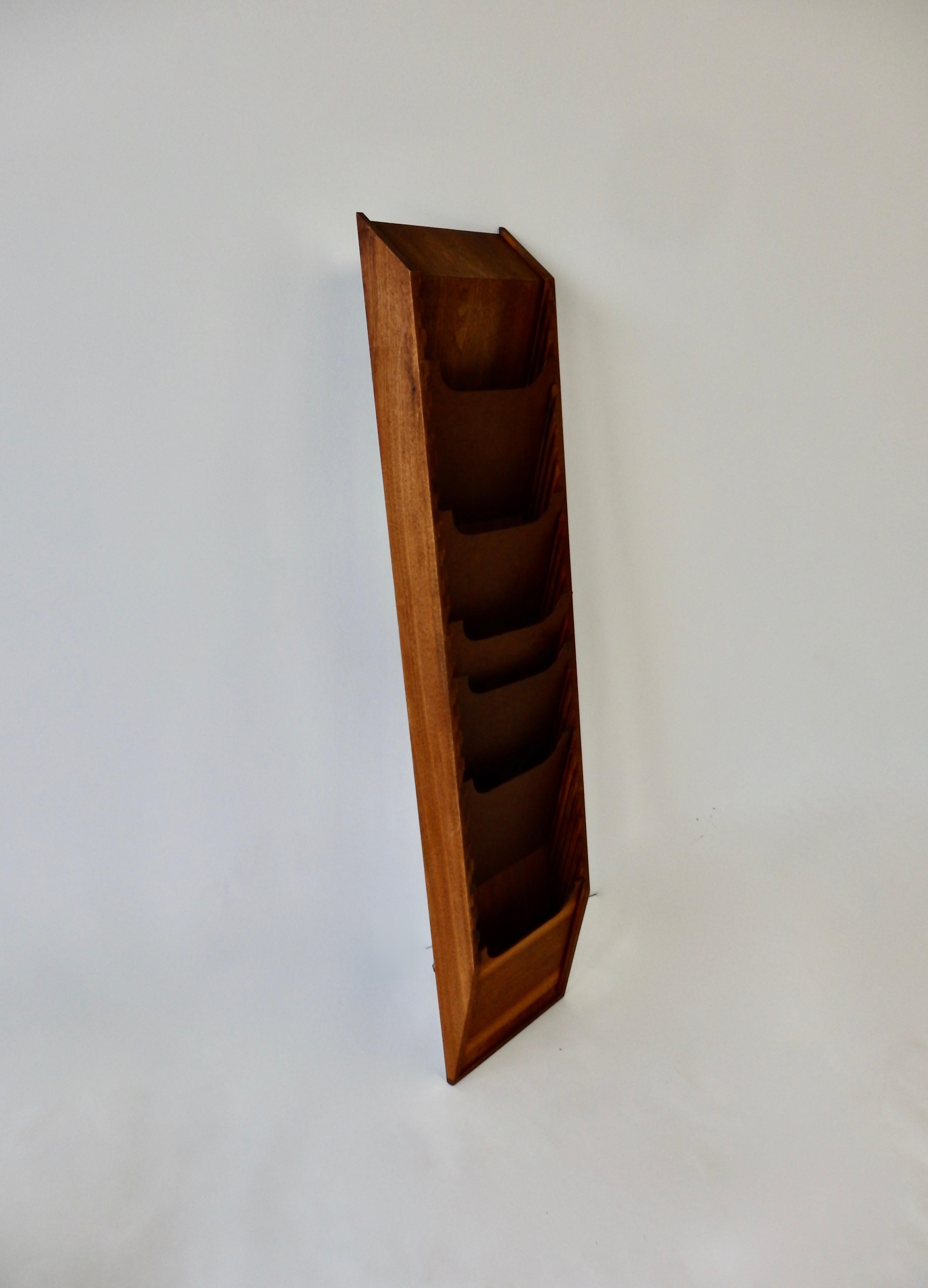 Wall mount walnut magazine display stand. Taller than most at almost five feet. Multiple Masonite adjustable dividers in dovetailed slats.