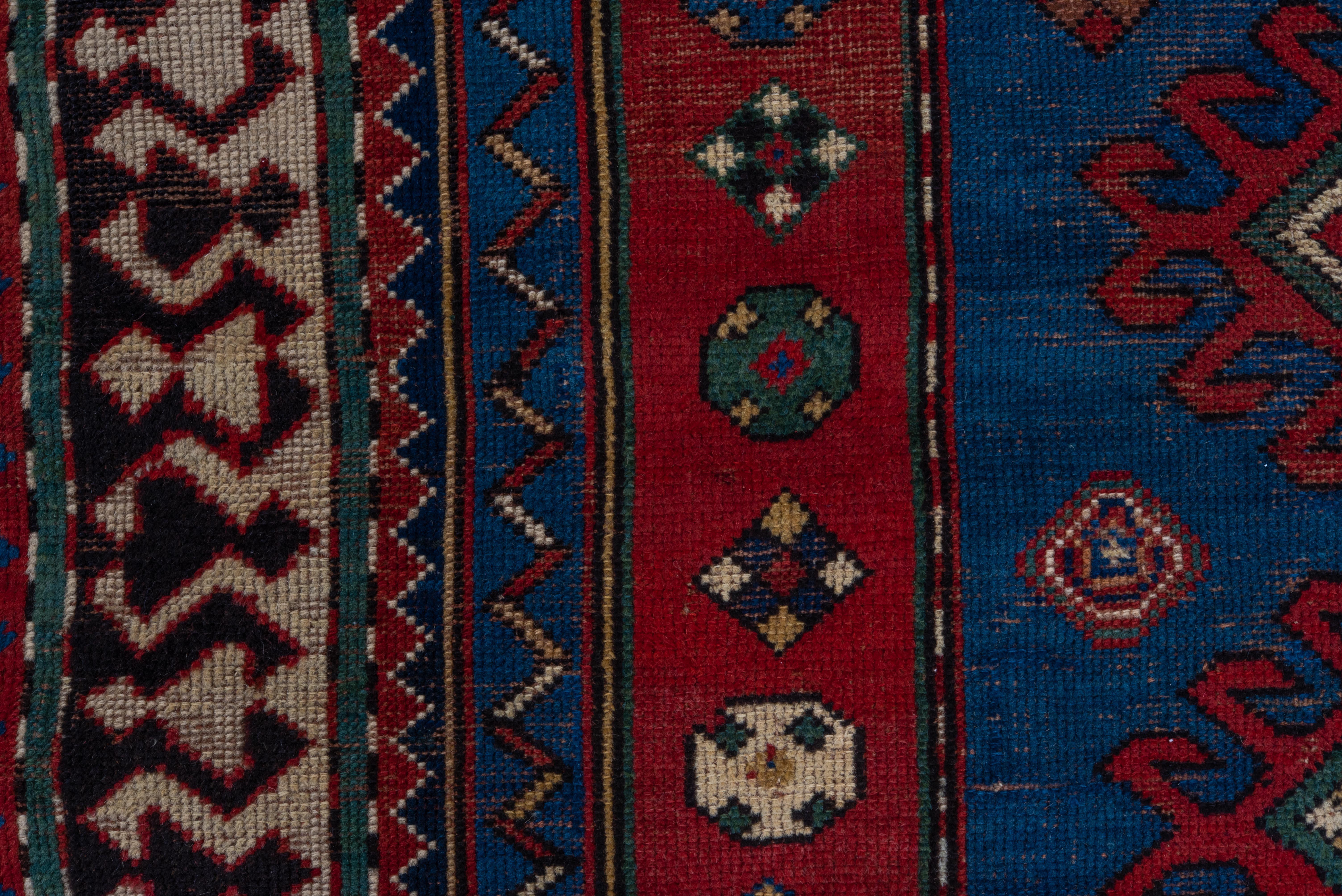 Wool Multi-Bordered Kazak with Tribal Geometric Influence in Reds and Blues  For Sale