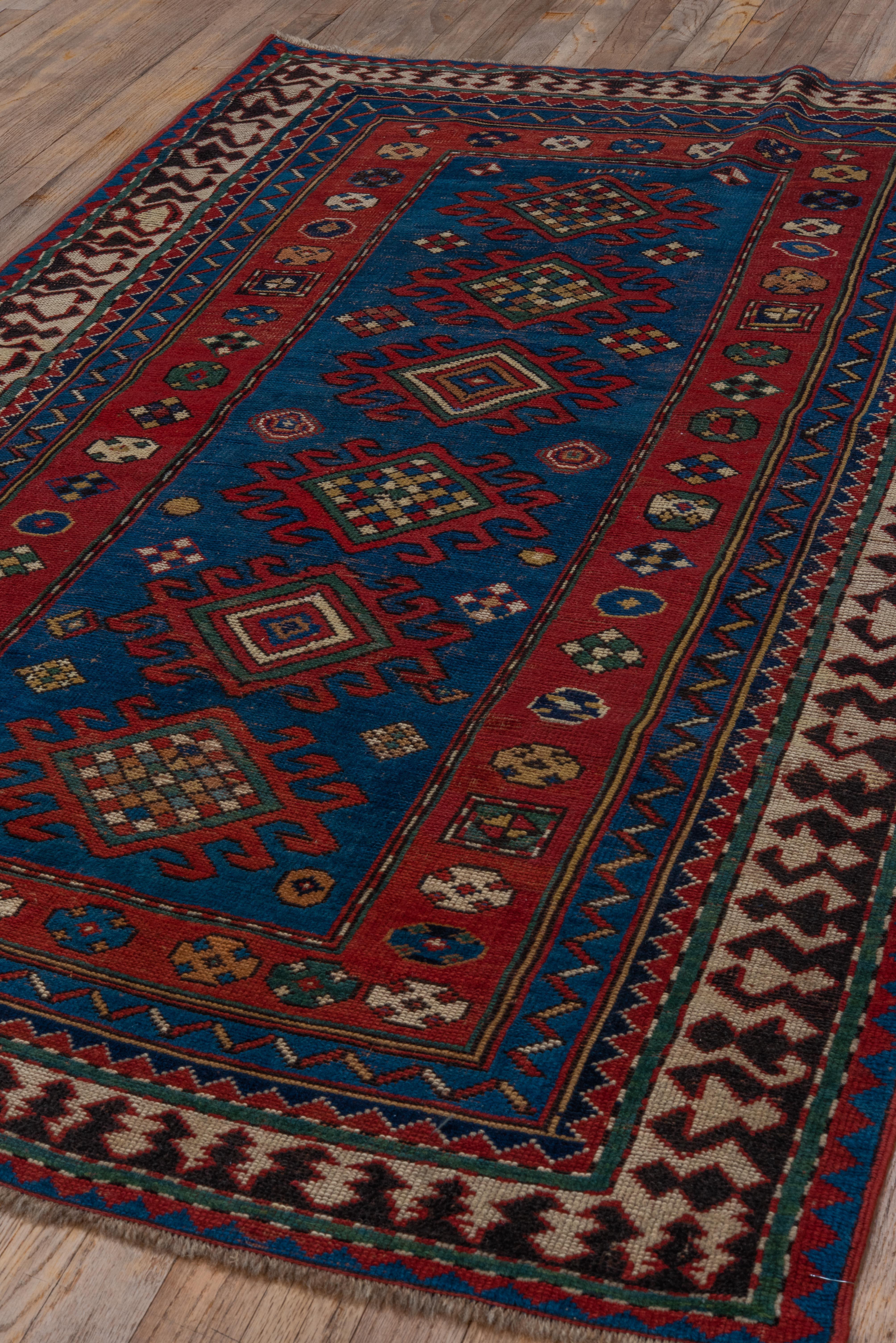 Multi-Bordered Kazak with Tribal Geometric Influence in Reds and Blues  For Sale 2