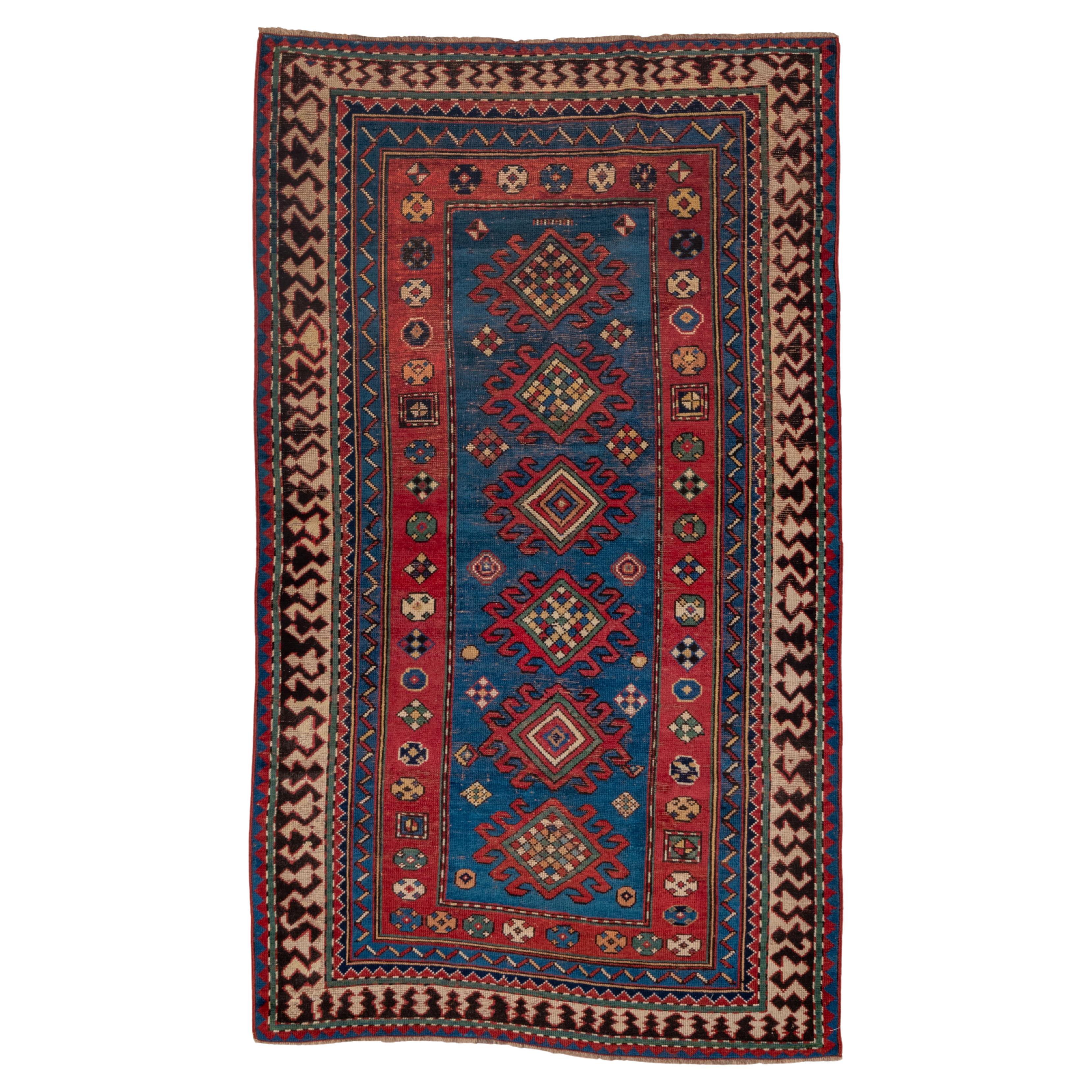 Multi-Bordered Kazak with Tribal Geometric Influence in Reds and Blues  For Sale