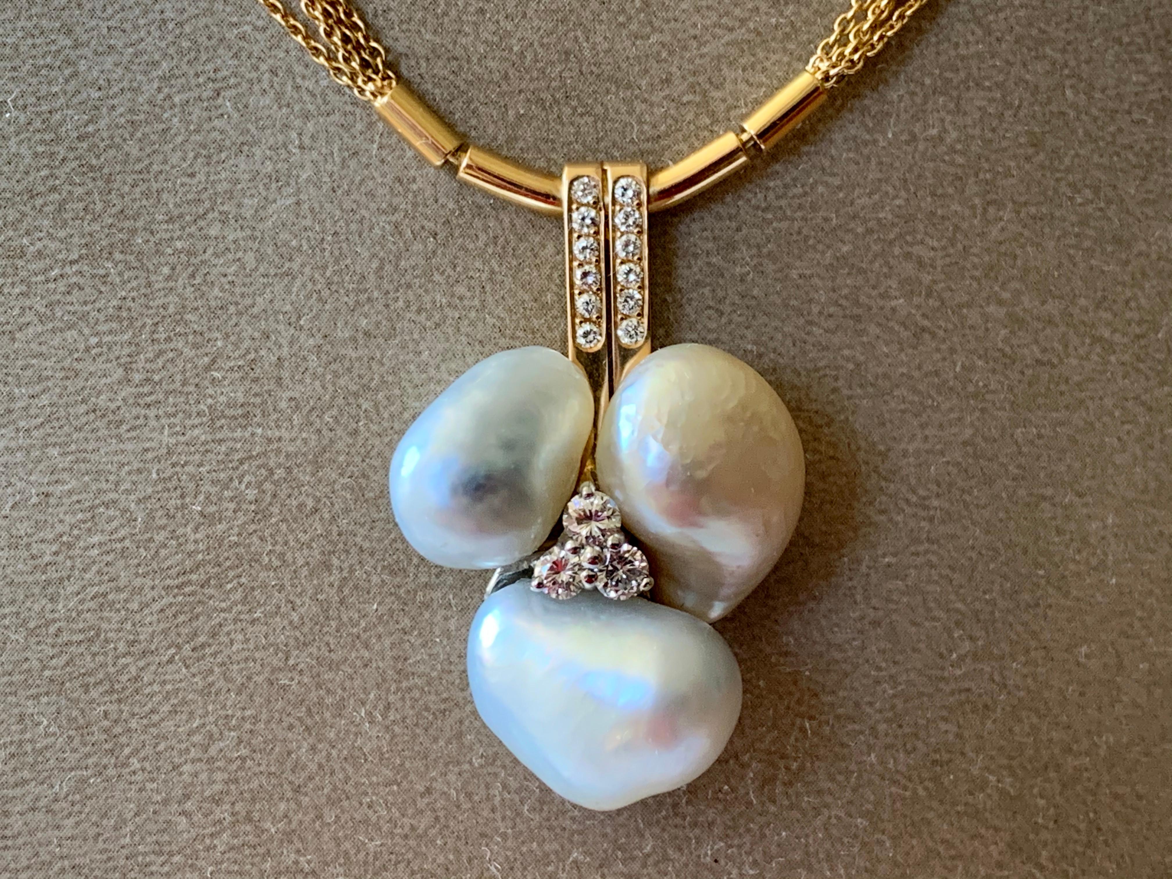 Collier unique en or jaune 18 K avec pendentif, réalisé par la société zurichoise de renommée internationale Binder. Le pendentif est serti de 3 peaux baroques et décoré de 15 diamants de taille brillante totalisant environ 0,60 ct. 
Toutes les