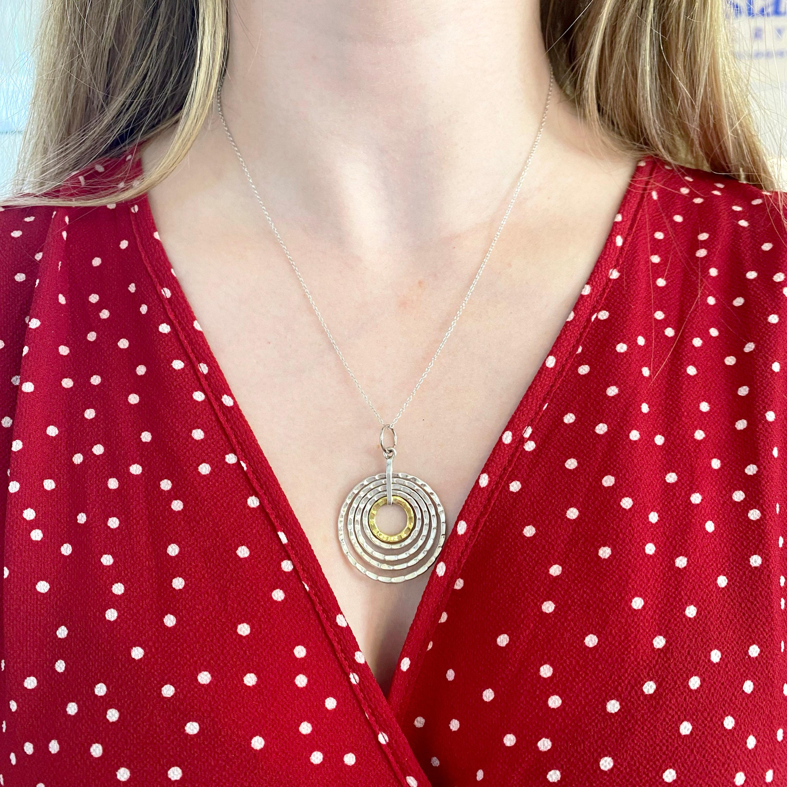 This circle statement necklace is a beautiful design of intrinsic circles.  Each circle is smaller than the next and individually formed and hand wrought with gorgeous hammering on the outside texture. The chain is an attractive cable chain that is