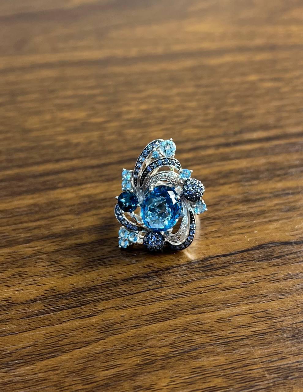A striking Blue Sapphire Multi-Stone Ring, featuring an exquisite Oval Blue Topazes set in 14K White Gold, adorned with additional Blue Sapphires and White Diamonds.
