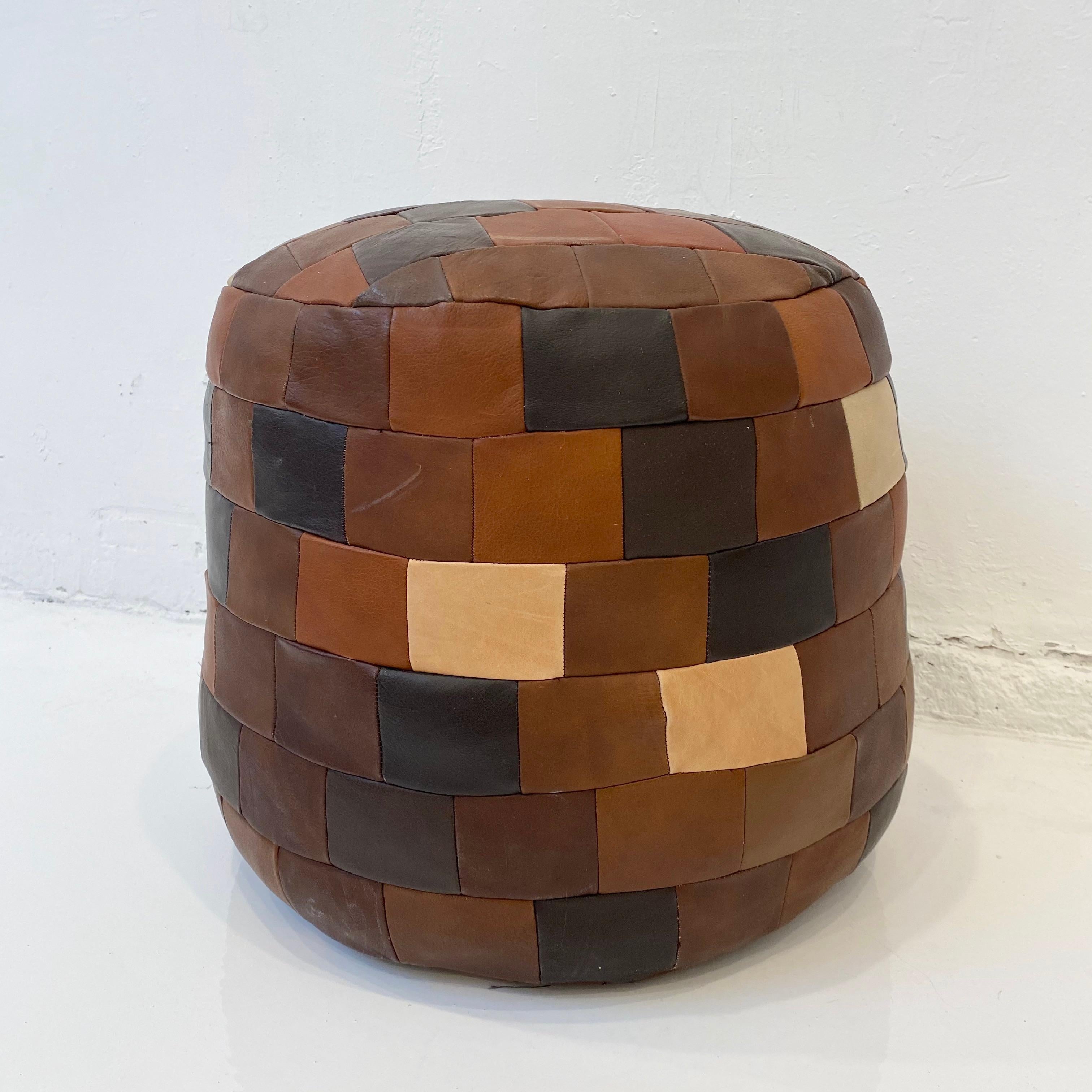 Unique patchwork leather ottoman by De Sede with multi-colored leather strips. Cylinder shape. various brown, tan and green leather colors. Great coloring and patina to leather. Very good condition. Great accent piece.

6-7 ottomans and beanbags