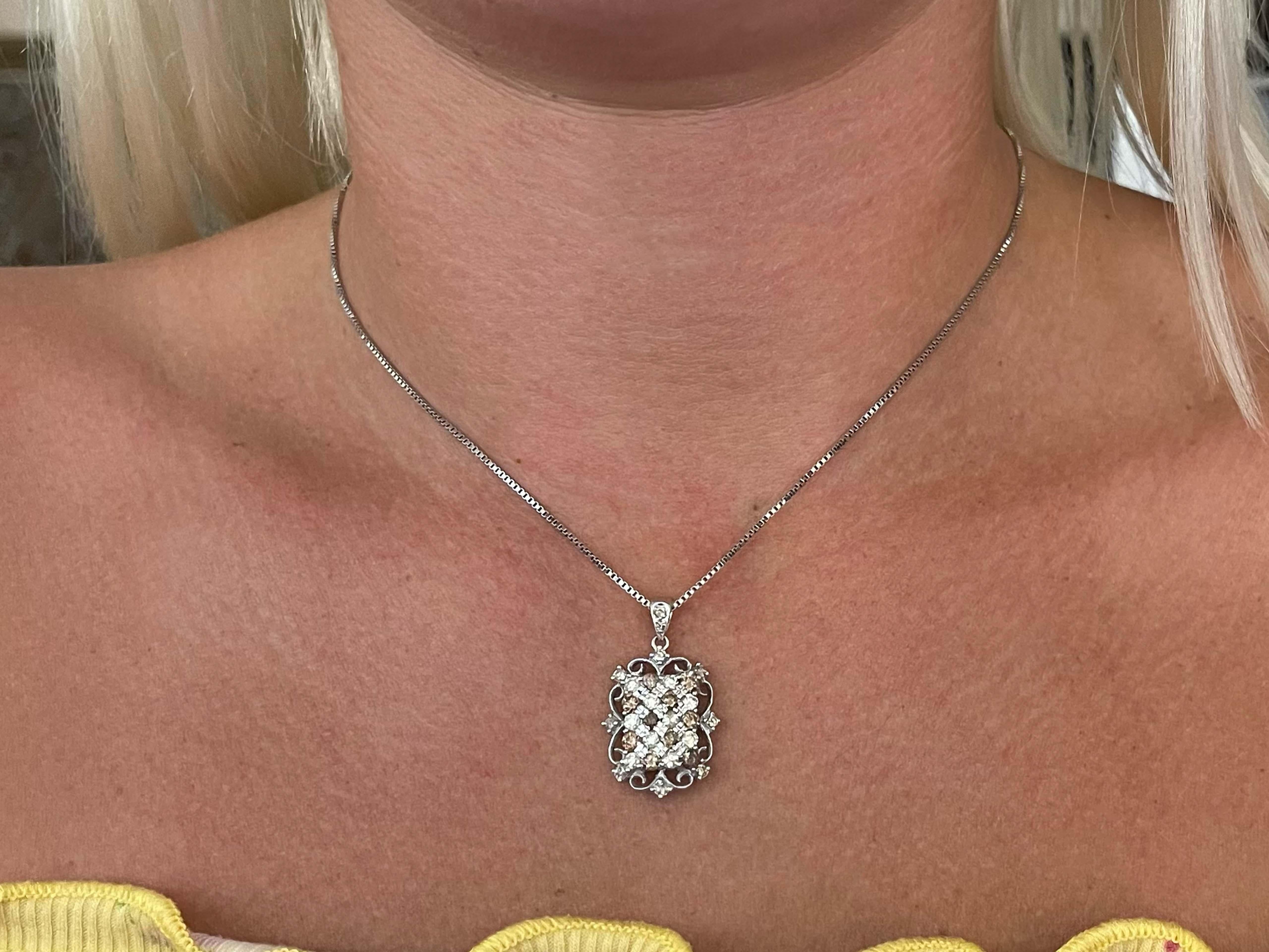 This pendant is truly unique featuring white and chocolate diamonds. The necklace features ~2.00 carats of round brilliant cut diamonds creating endless sparkle. The white diamonds are K-L in color and appear yellow. All the diamonds are SI2-I1 in