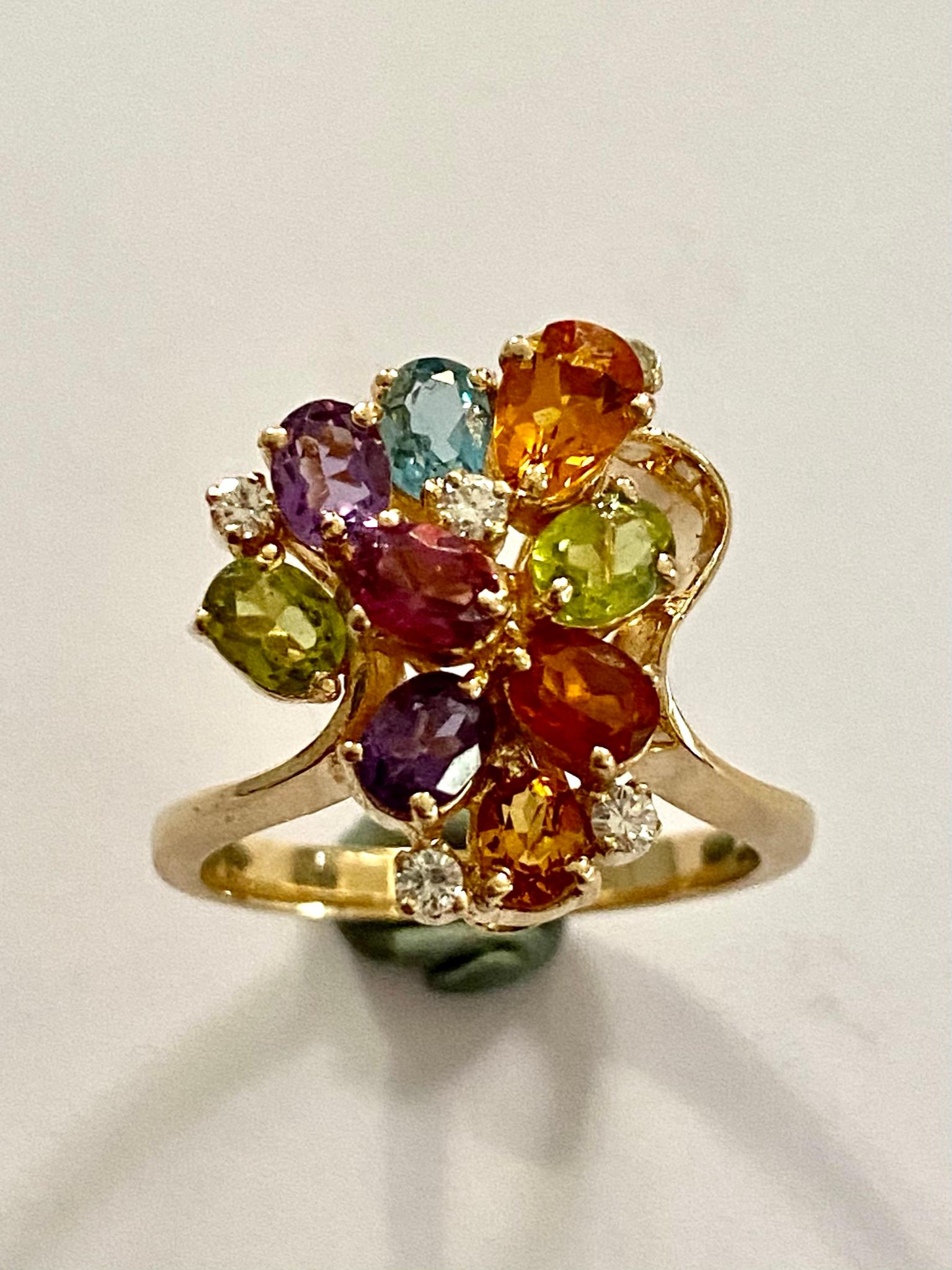One (1) 14 Karat Yellow Gold Ring, stamped 585,  weight: 5.83 grams.
set with:
5 Brillant cut diamonds = 0.10 ct. VS - F-G
3 Citien, 2 Peridots, 2 Amethyst, 1 Blue Topas (treated) 1 Rhodolite.
Made in Germany  1970
