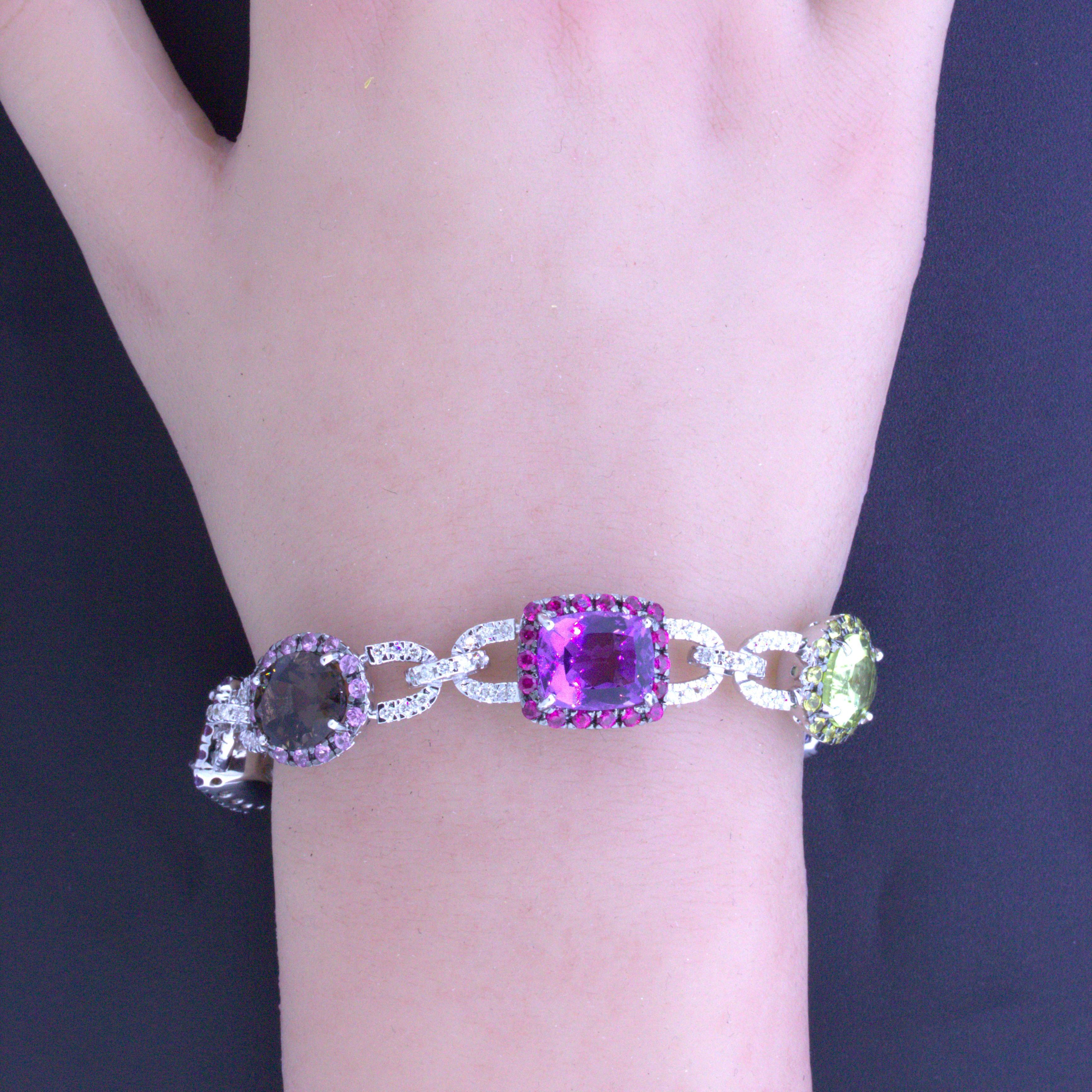 Ein helles und farbenfrohes Armband mit einer Vielzahl von farbigen Edelsteinen! Dazu gehören Blautopas, Citrin, Amethyst und Rauchquarz sowie Rubine und blaue Saphire. Zusätzlich funkeln 1,55 Karat runde Diamanten im Brillantschliff in dem