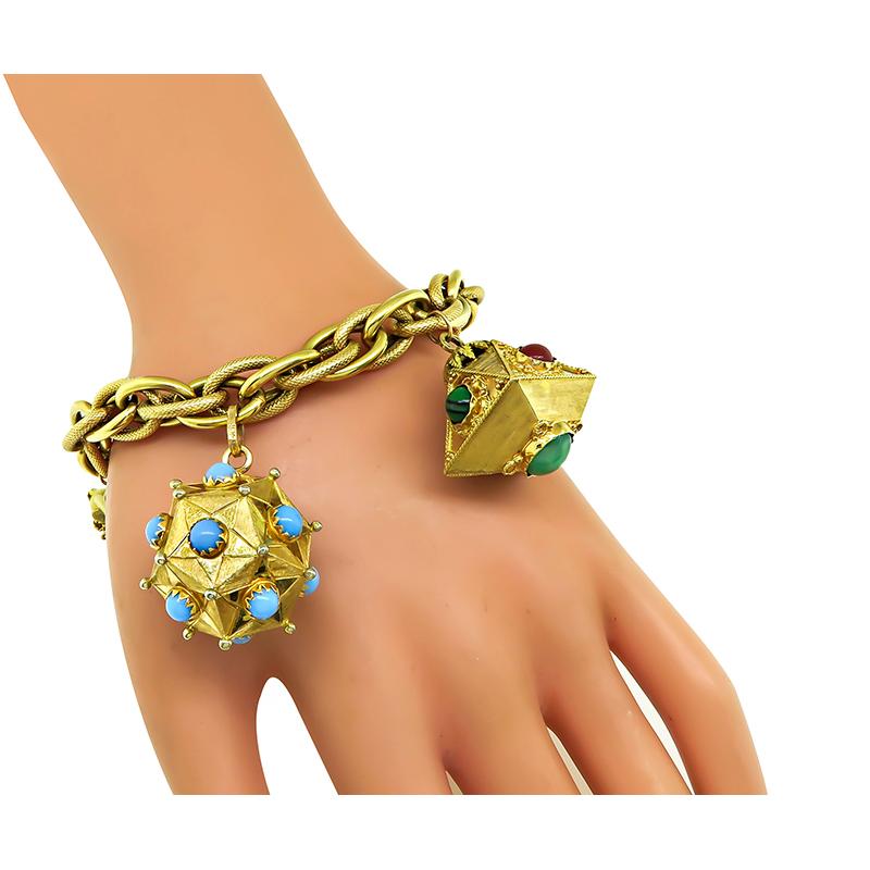 This is a fabulous 18k yellow gold charm bracelet. The bracelet features 5 pieces novelty charms in 18k yellow gold which are 3 lanterns, vintage phone and vintage pitcher. The charms are adorned with semi precious stone which are turquoise,