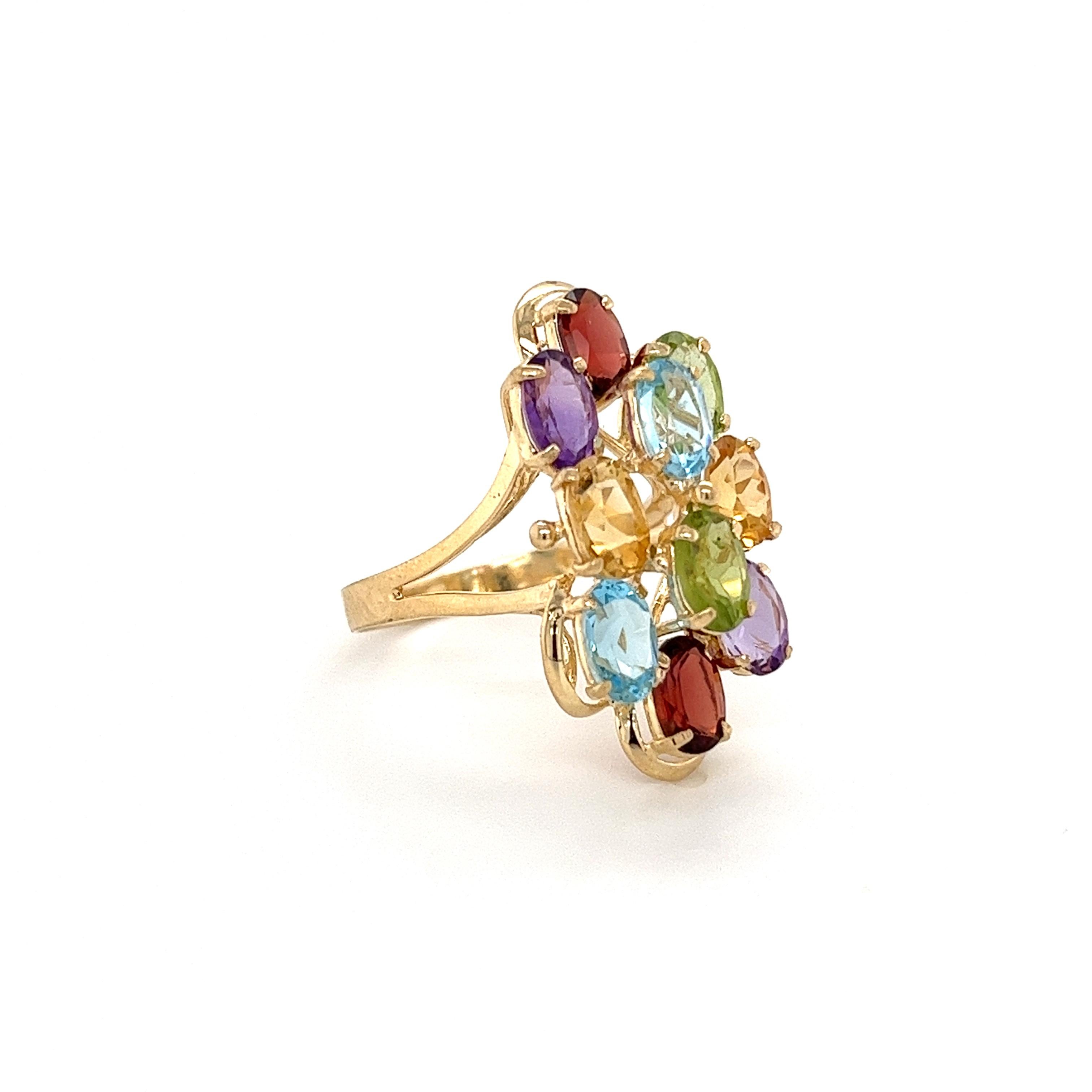 Anello a grappolo con gemme colorate in oro massiccio 14K. Questo splendido anello ospita una coppia di gemme di Topazio, Peridoto, Granato, Ametista e Citrino. Ogni coppia di gemme è parallela all'altra e di taglio ovale brillante.

Karatura