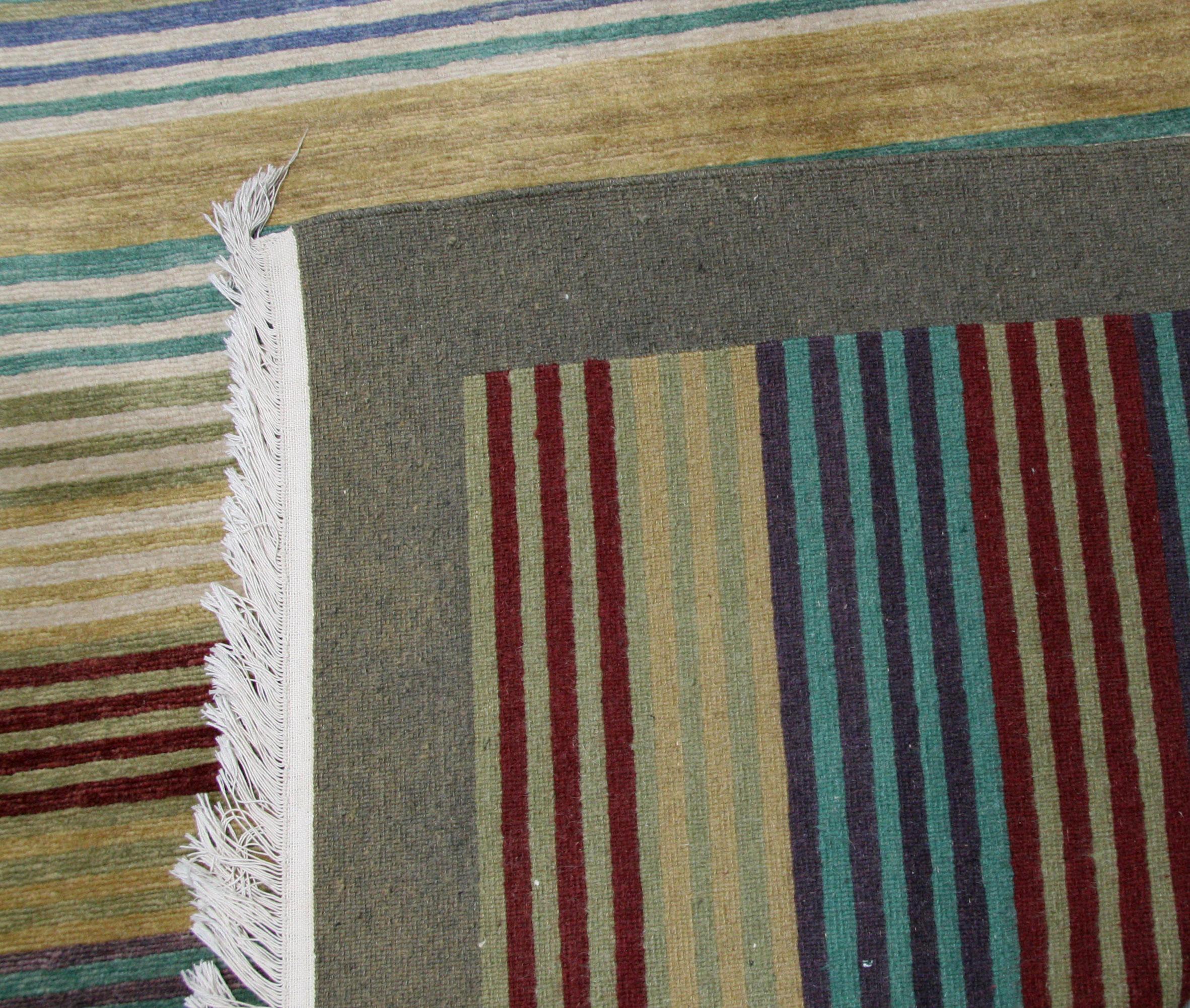 The look of a kilim in a wool pile rug. Multicolored stripes bring the look of a traditional kilim but with the dense pile and durability of a wool rug. A great family-friendly rug for casual living spaces. Hand knotted in India using wool dyed with