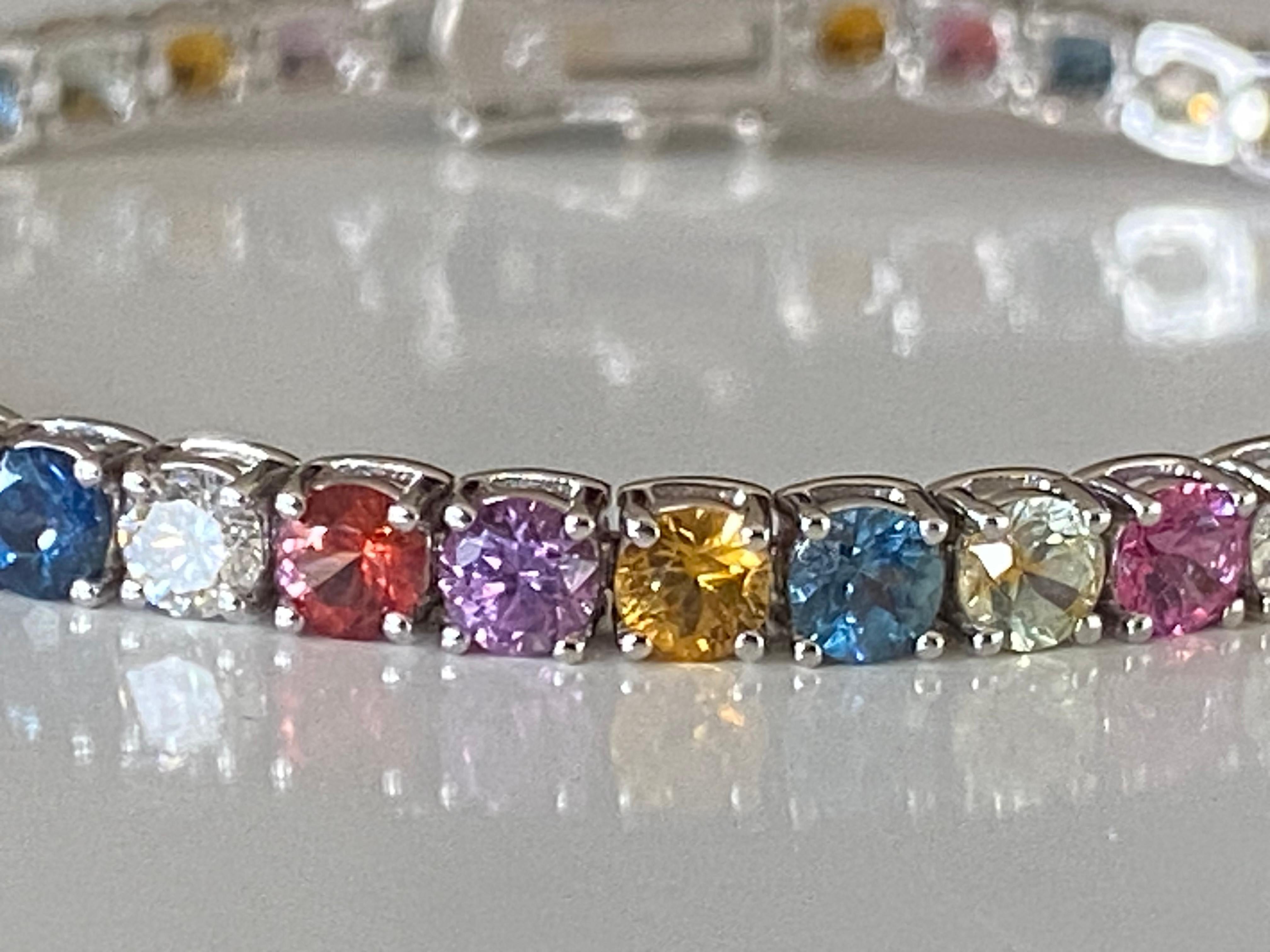 This exquisite tennis bracelet is set with 42 natural round multi-color sapphires mined in Montana totaling 9.67 carats interspersed with 9 natural round diamonds totaling 0.97 carats, G-H color, SI1 clarity. The bracelet is handcrafted in 18kt