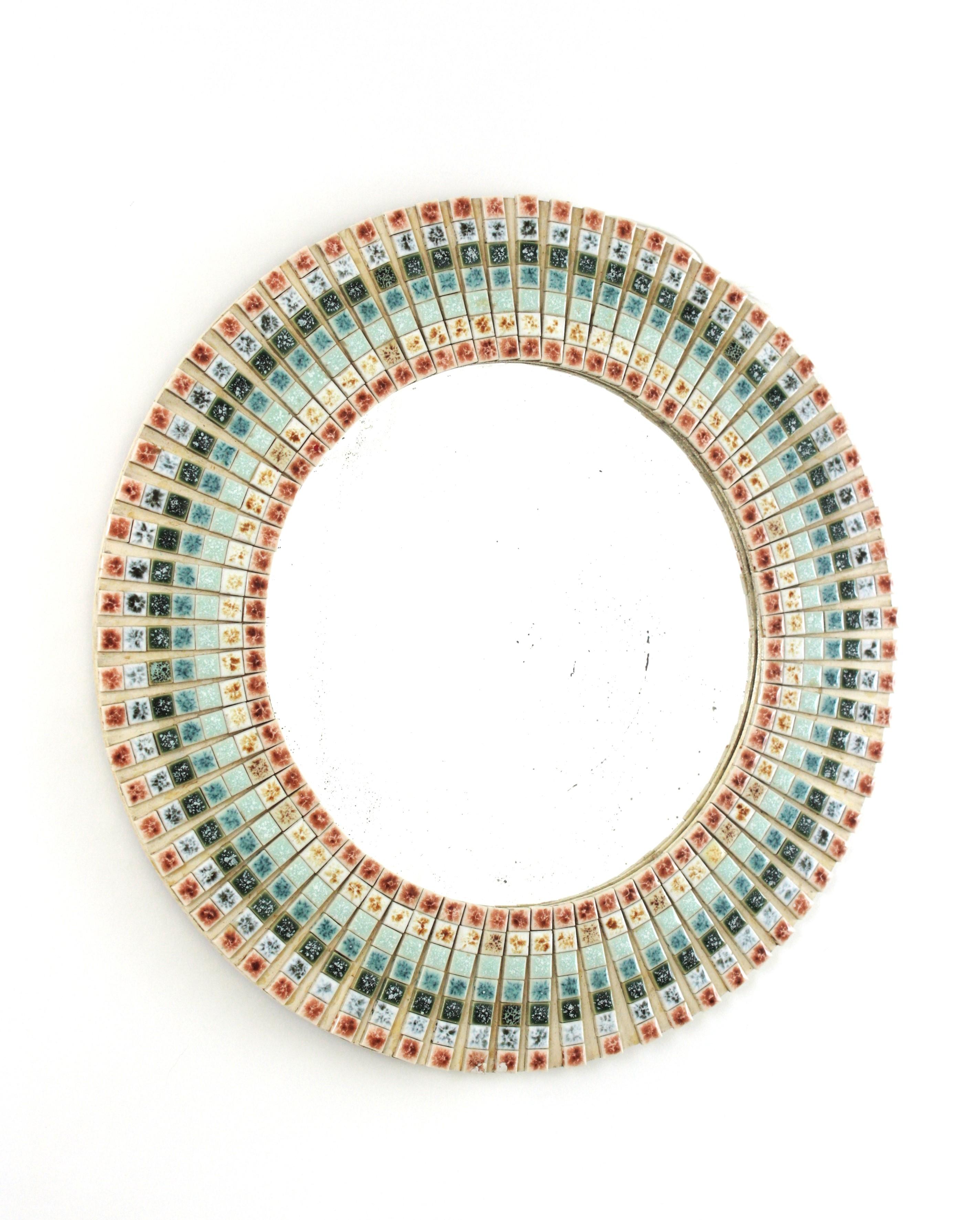 Espejo circular de mosaico de azulejos multicolores modernos de mediados de siglo, cerámica
España, 1950-1960
Llamativo espejo de pared enmarcado con pequeños azulejos de cerámica en colores pastel moteados: blanco, rojo, amarillo, azul, verde y
