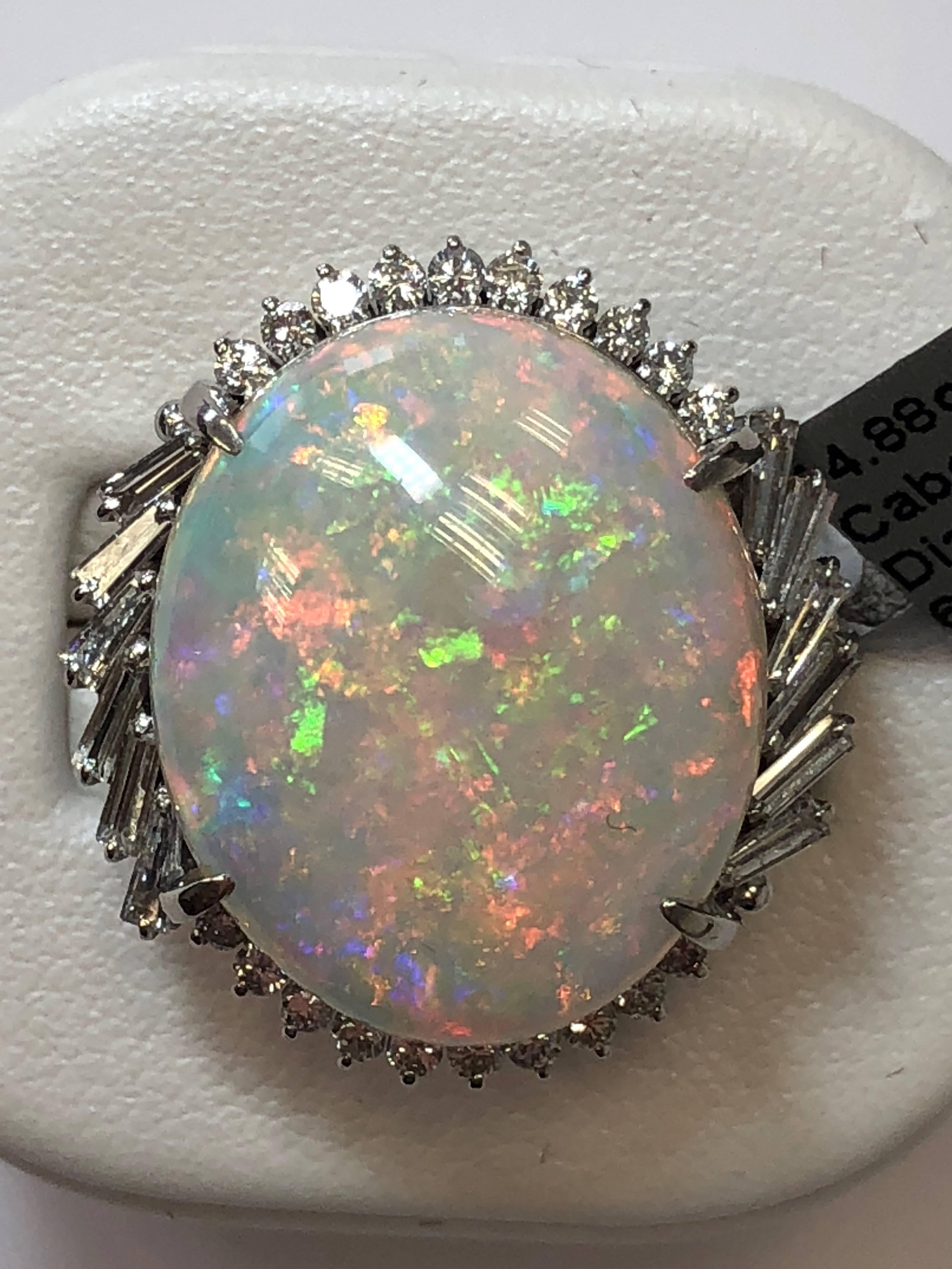 14.88 carat multi color opal cabochon with 0.97 carats of white diamonds in a platinum ring.  This opal has a gorgeous vibrant color that would make any outfit shine.  Size 6.25.