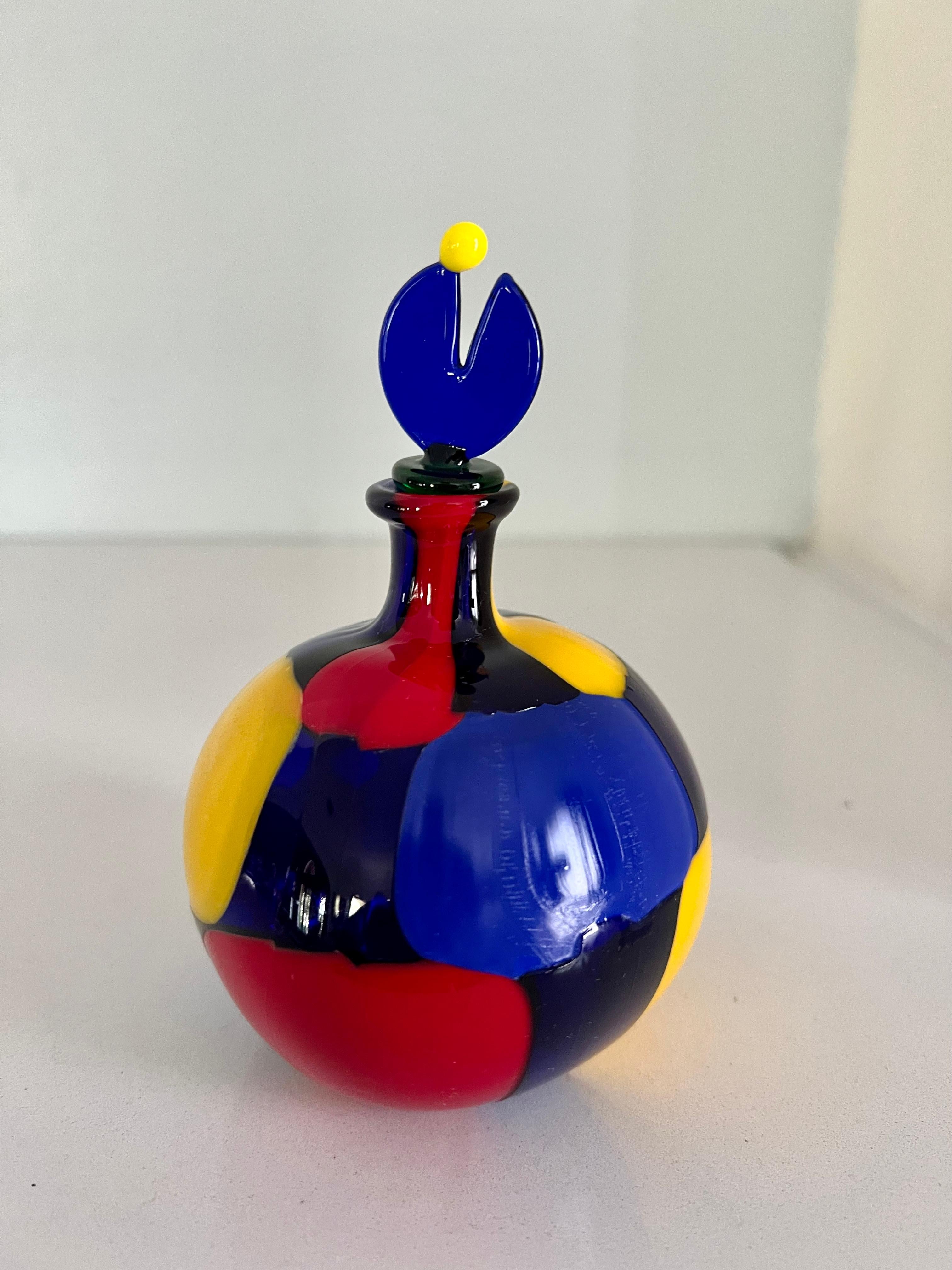 A wonderful multi color Murano Glass perfume bottle - a stunning departure from the norm, with opaque glass and vibrant solid colors. A compliment to any dressing table, vanity or bathroom with a stylish component. The glass stopper has a stem for