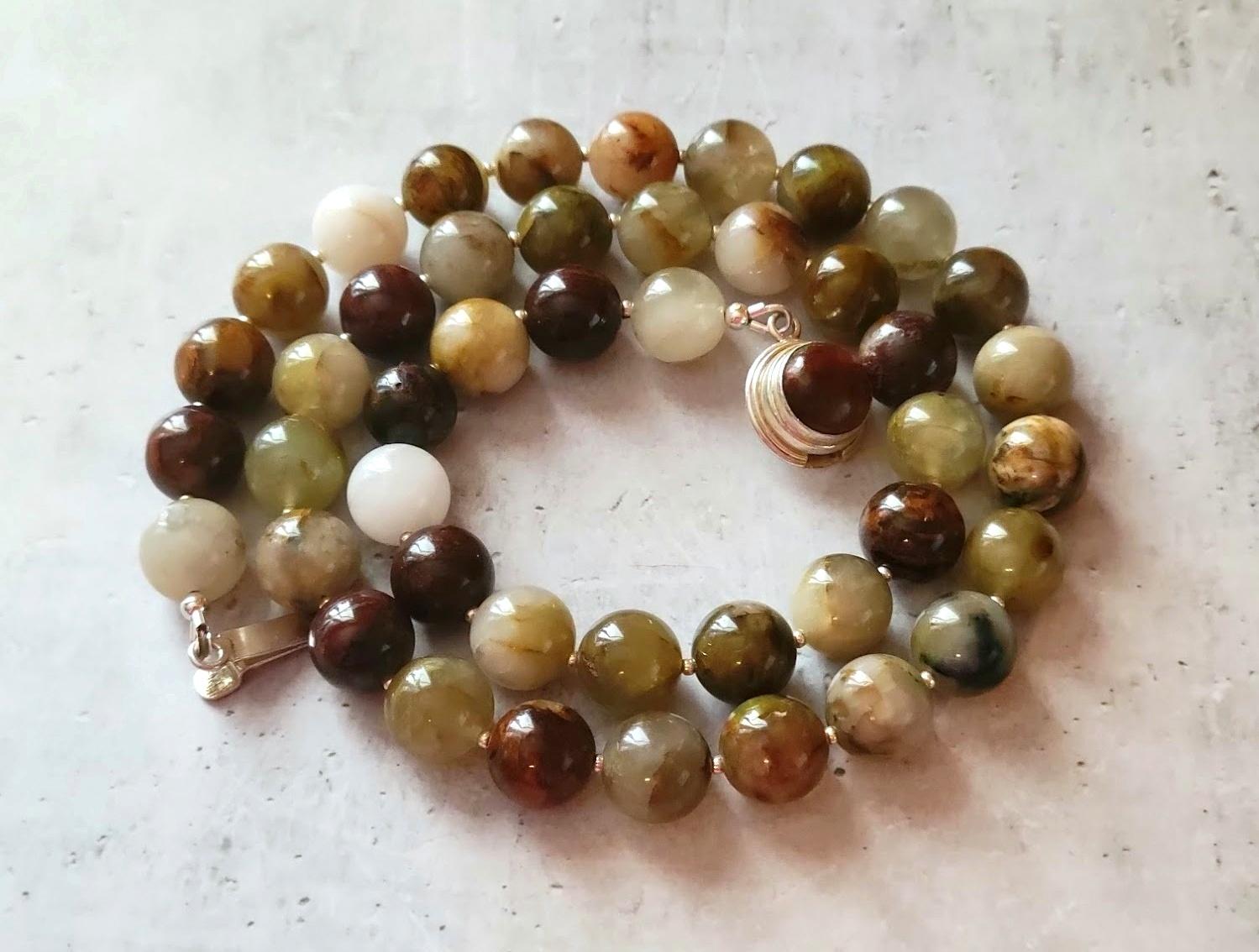 La lunghezza della collana è di 24 pollici (61 cm). La dimensione delle perline tonde lisce è di 12 mm.
La collana è chiusa da un bellissimo fermaglio in argento sterling con un cabochon di pietersite naturale.
Questa collana alterna perline di