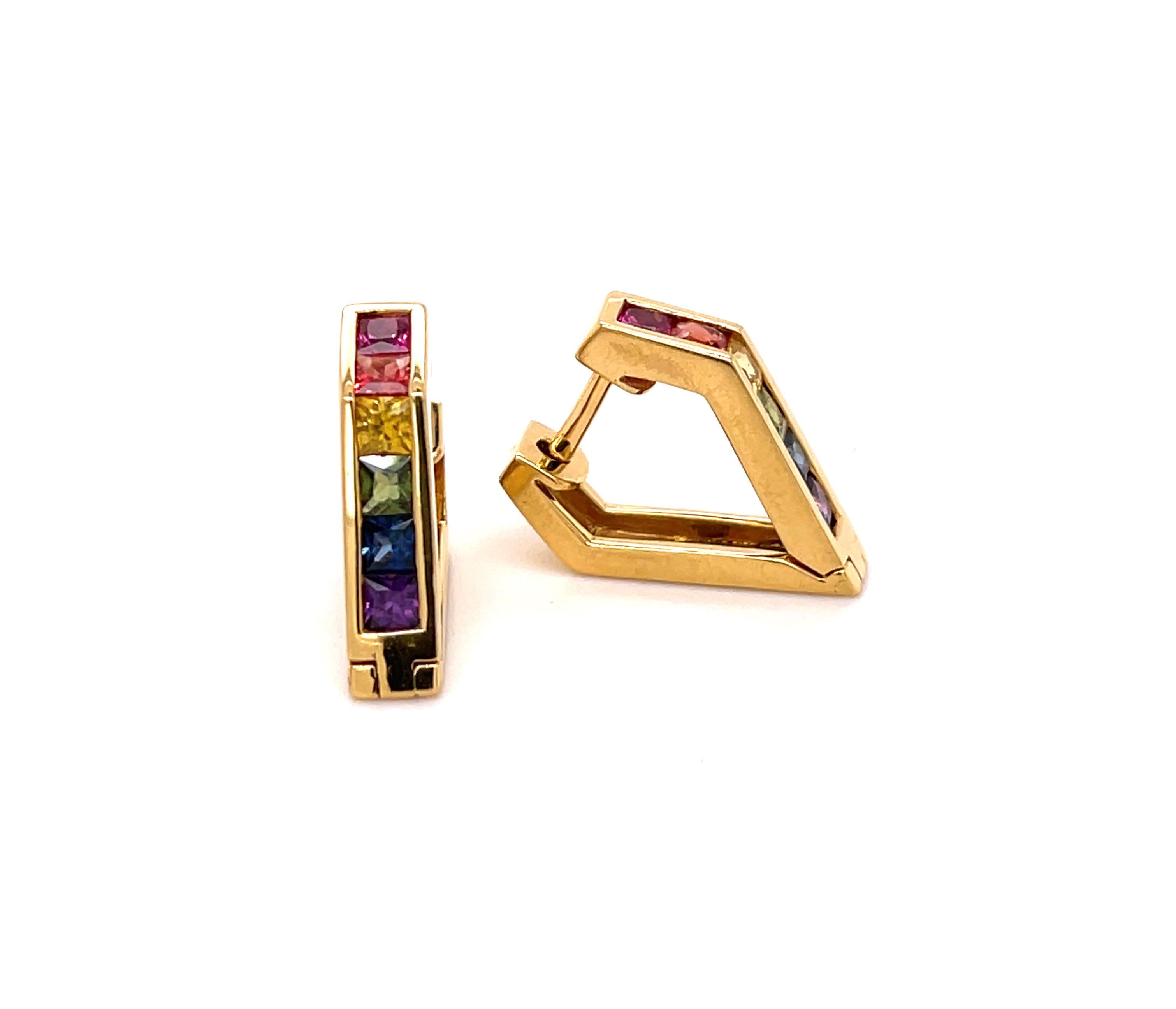 These multi-color Hoop-Earrings have a contemporary shape and they are not the traditional round Huggies. Done in 18-karat yellow gold this pair has a total of 1.25 carats of 12 princess cut 2.5 mm multi-colored Sapphire. The earrings are 15 mm