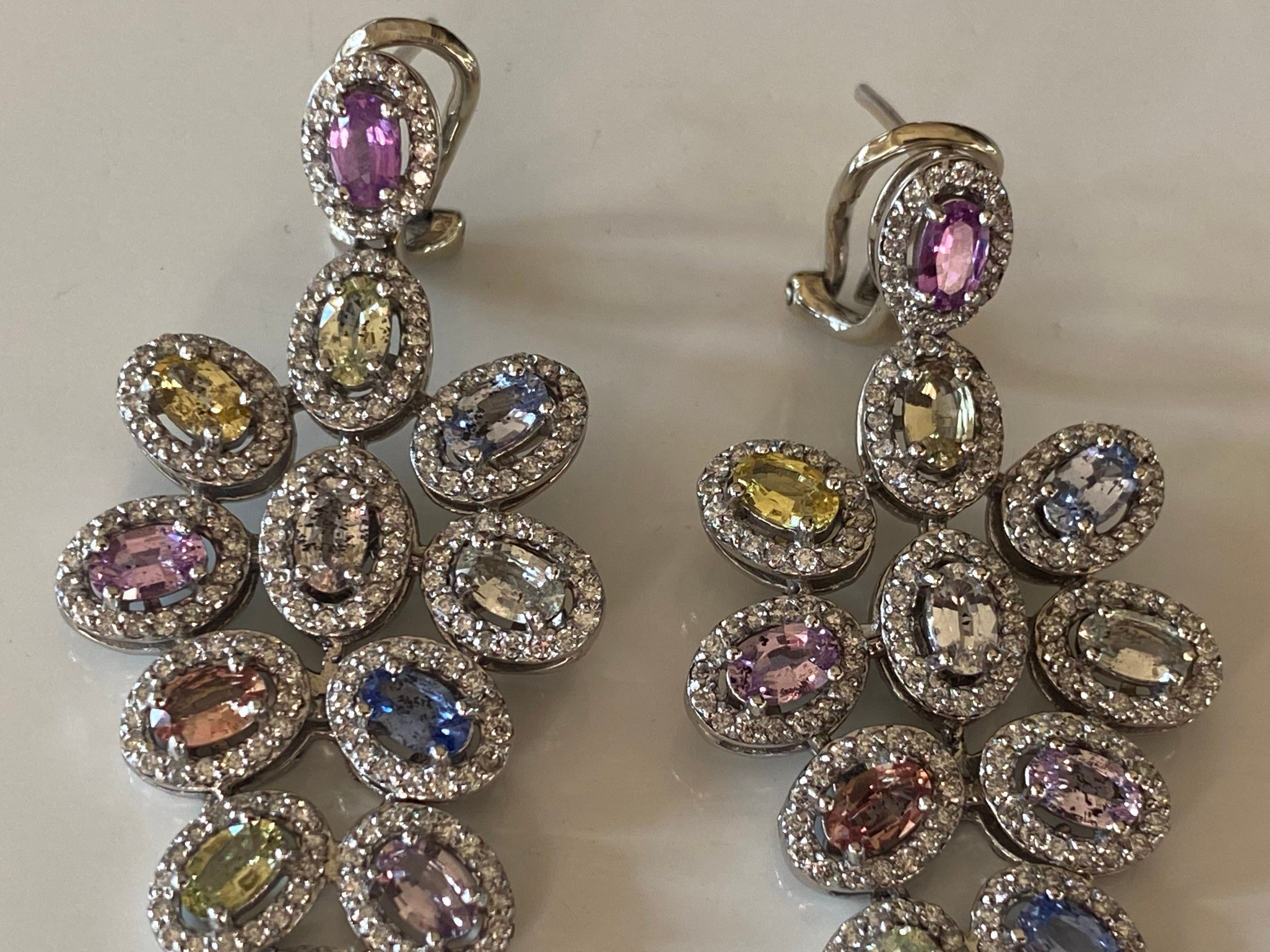 These exquisite drop down earrings set in 14kt white gold feature 32 multi-color unheated sapphires and 480 natural round diamonds, G-H color, SI clarity secured with omega clips. The diamonds total 2.50 carats and the sapphires total 8.00 carats.