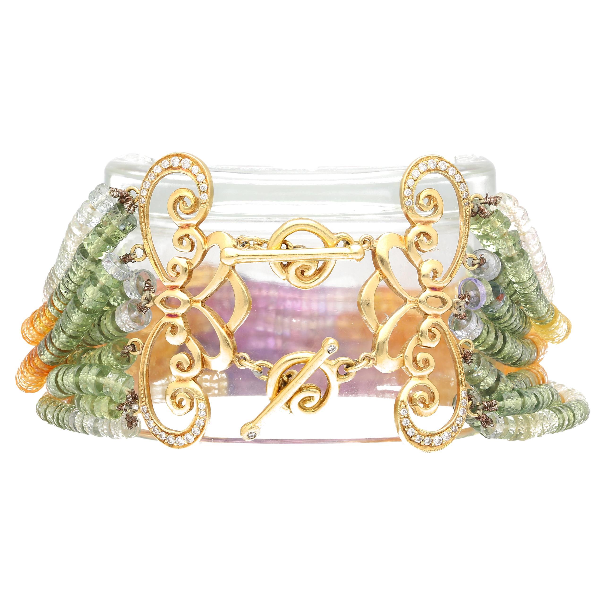 Bracelet de perles de saphir multicolores et de diamants en or jaune 18 carats. Un bracelet en saphir naturel et diamant sur le thème de l'arc-en-ciel qui épouse le poignet et éblouit par ses couleurs.

Ce bracelet en perles comporte 10 brins de