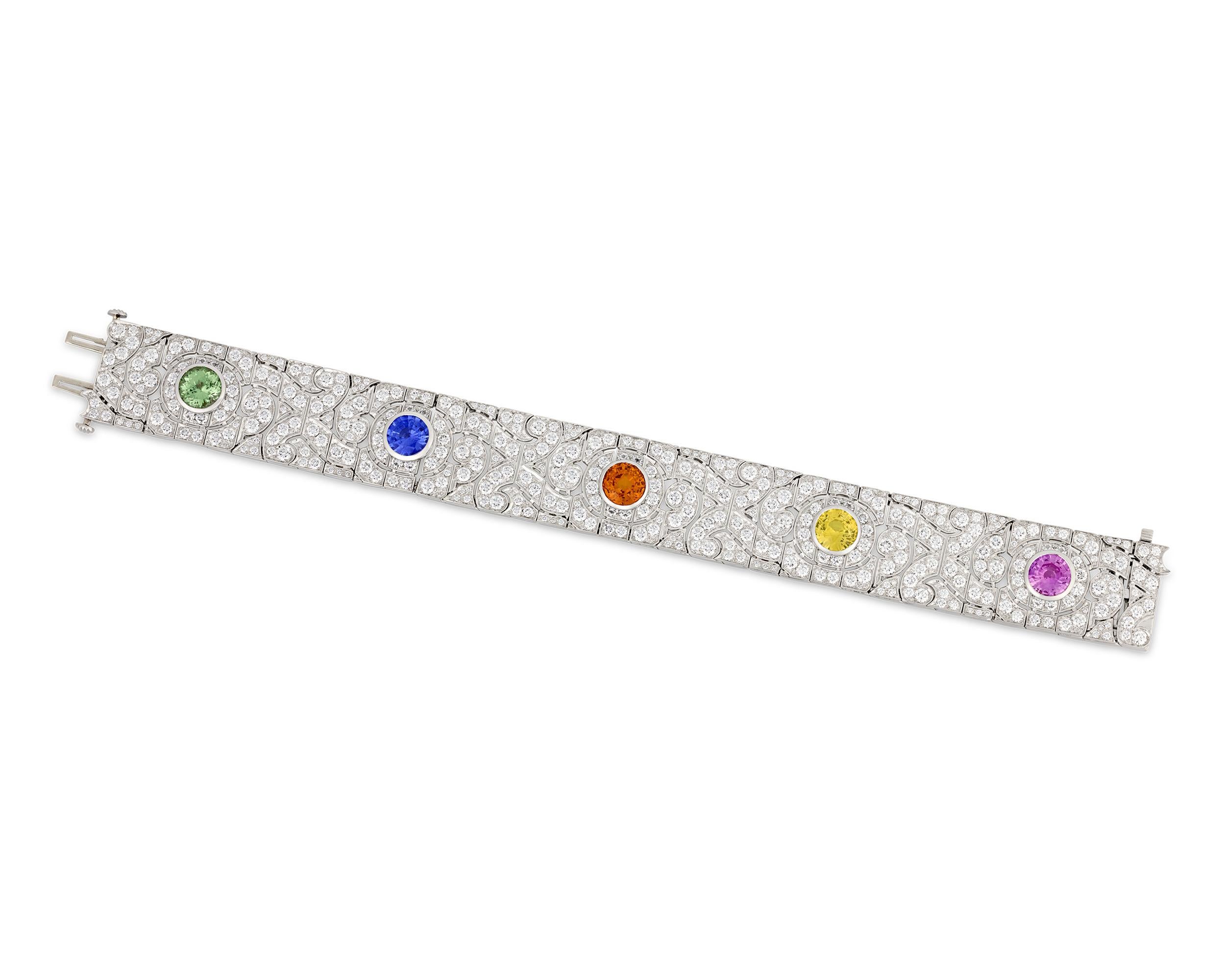 This exquisite bracelet from celebrated jewelry designer Oscar Heyman features a rainbow of colorful gemstones set amongst a sea of sparkling white diamonds. The design features a 2.71-carat orange sapphire, a 1.72-carat pink sapphire, a 1.73-carat