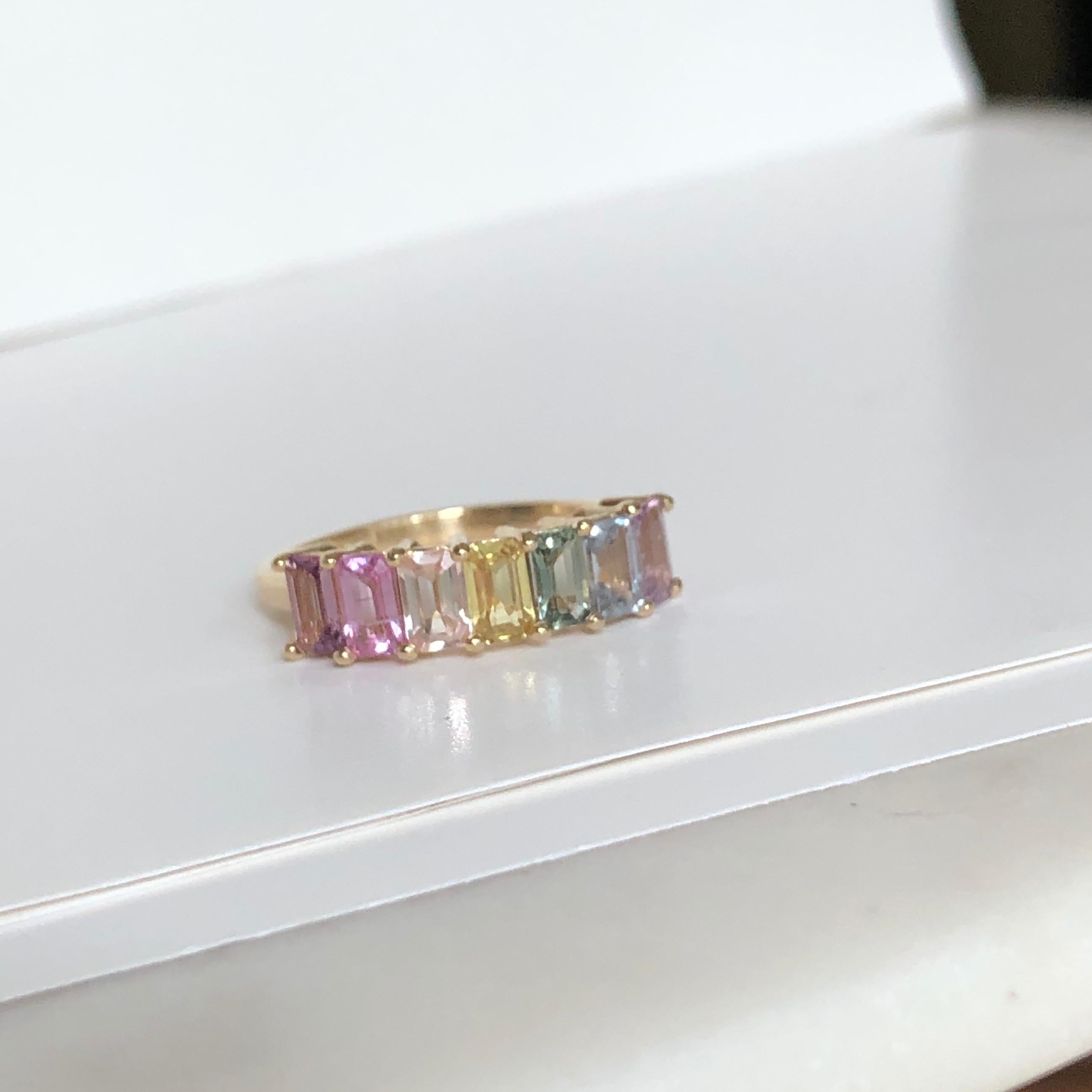 This Graduating Rainbow 100% natural-untreated Sapphire Half Eternity Engagement Band 14K yellow gold ring is a beautiful piece to add to your collection. Set with 7 emerald cut natural, no heat rainbow multi-color sapphires weighing 2.44 carats,