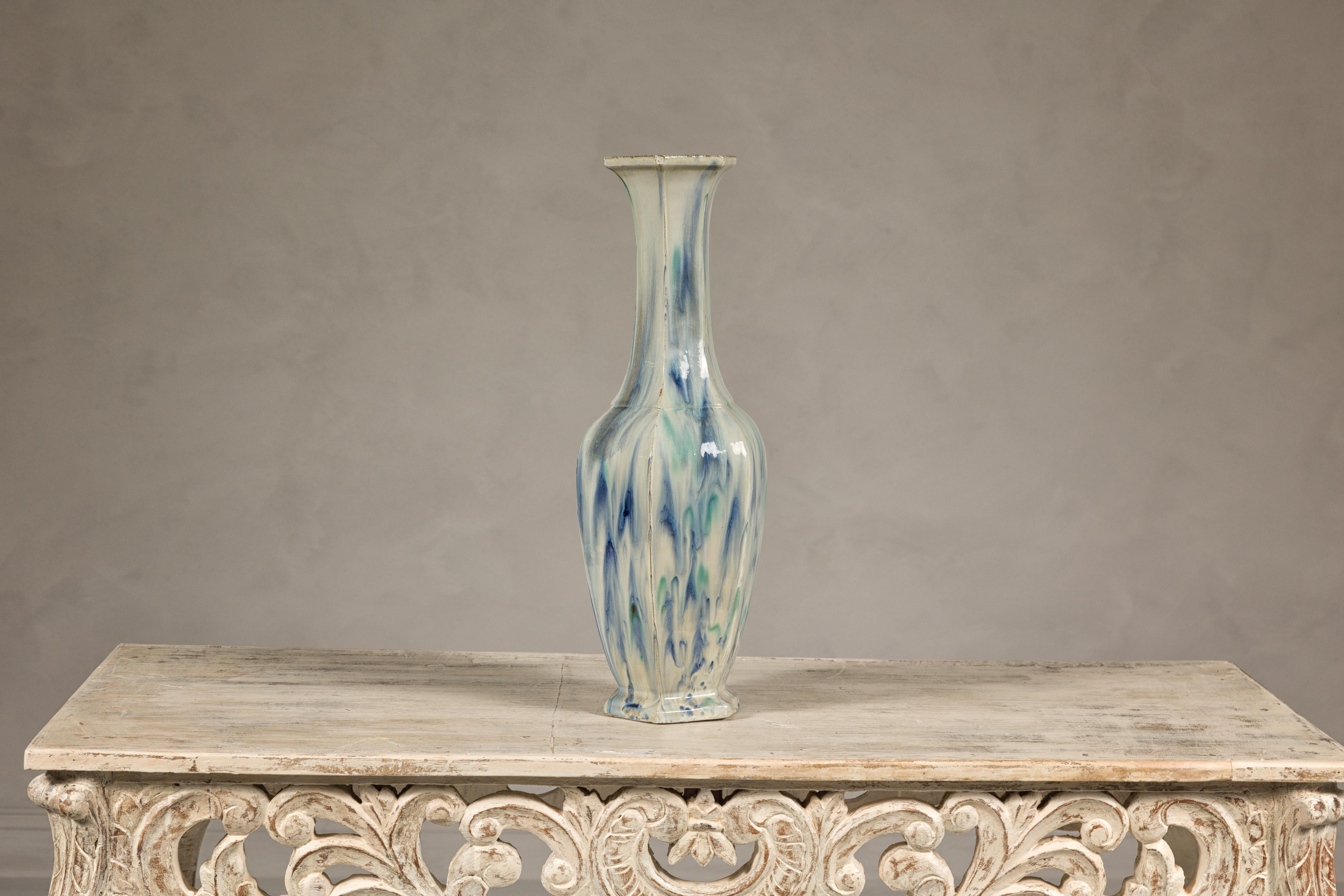 Diese mehrfarbige Tropfvase im Vintage-Stil besticht durch ihr einzigartiges Design und ihre subtile Farbpalette, die einen cremefarbenen Grund mit fließenden blauen und grünen Tropfen verbindet. Der ausladende Hals verleiht dem Stück einen