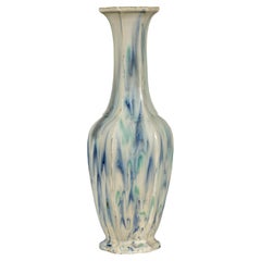 Vaso multicolore con accenti blu e verdi a goccia su fondo color crema