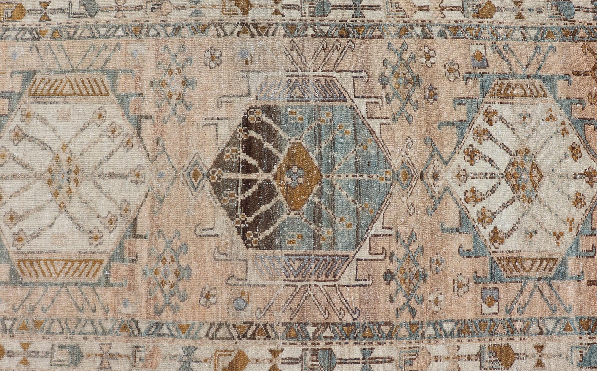 Multi colored antique Persian Heriz Runner with Geometric Medallions. Keivan Woven Arts / rug EMB-9664-P13557, country of origin / type: Iran / Heriz, circa 1920

This Persian Heriz runner carpet from the early-20th century (circa 1920) bears an