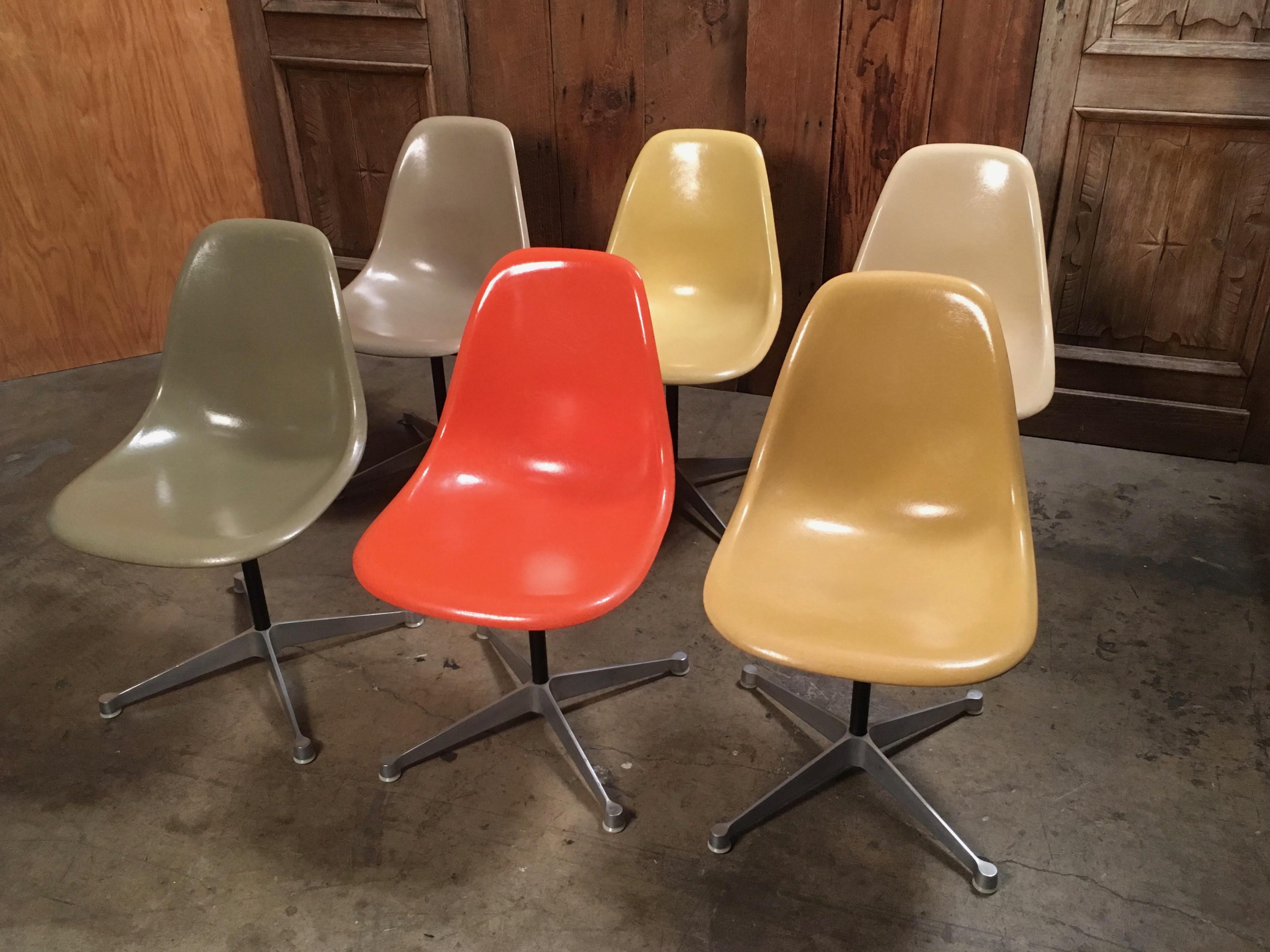 Set of six Mid-Century Modern fiberglass swivel side shell chairs designed by Charles and Ray Eames, manufactured by Herman Miller. Remarkable condition for the age, early example, beautiful multi colored fiberglass side shells atop cast aluminum