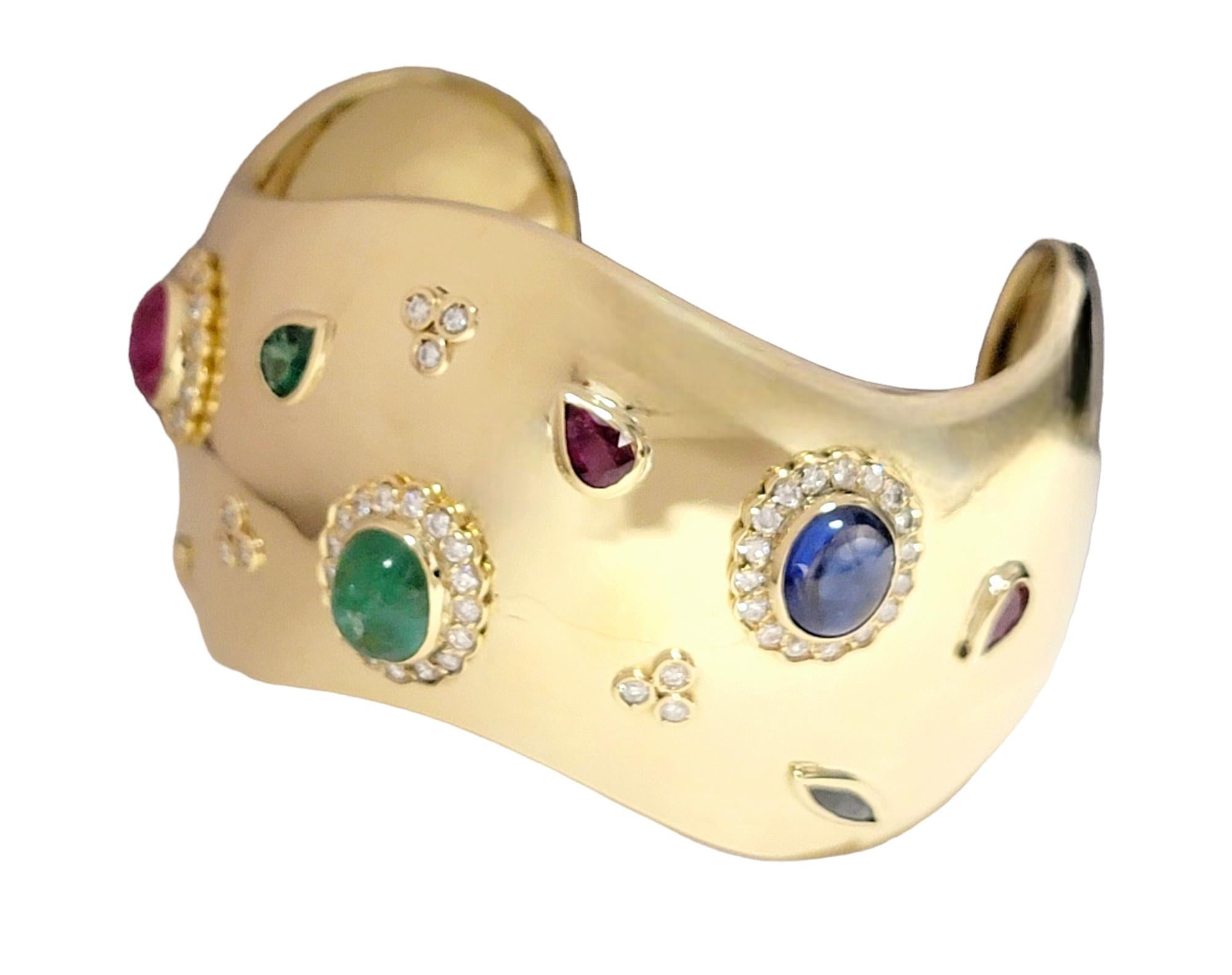 This extraordinary gold cuff bracelet is the epitome of elegance, set resplendent 18 karat yellow gold. A canvas of pure luxury, the bracelet is adorned with a dazzling array of gemstones—diamonds, rubies, sapphires, and emeralds—each meticulously