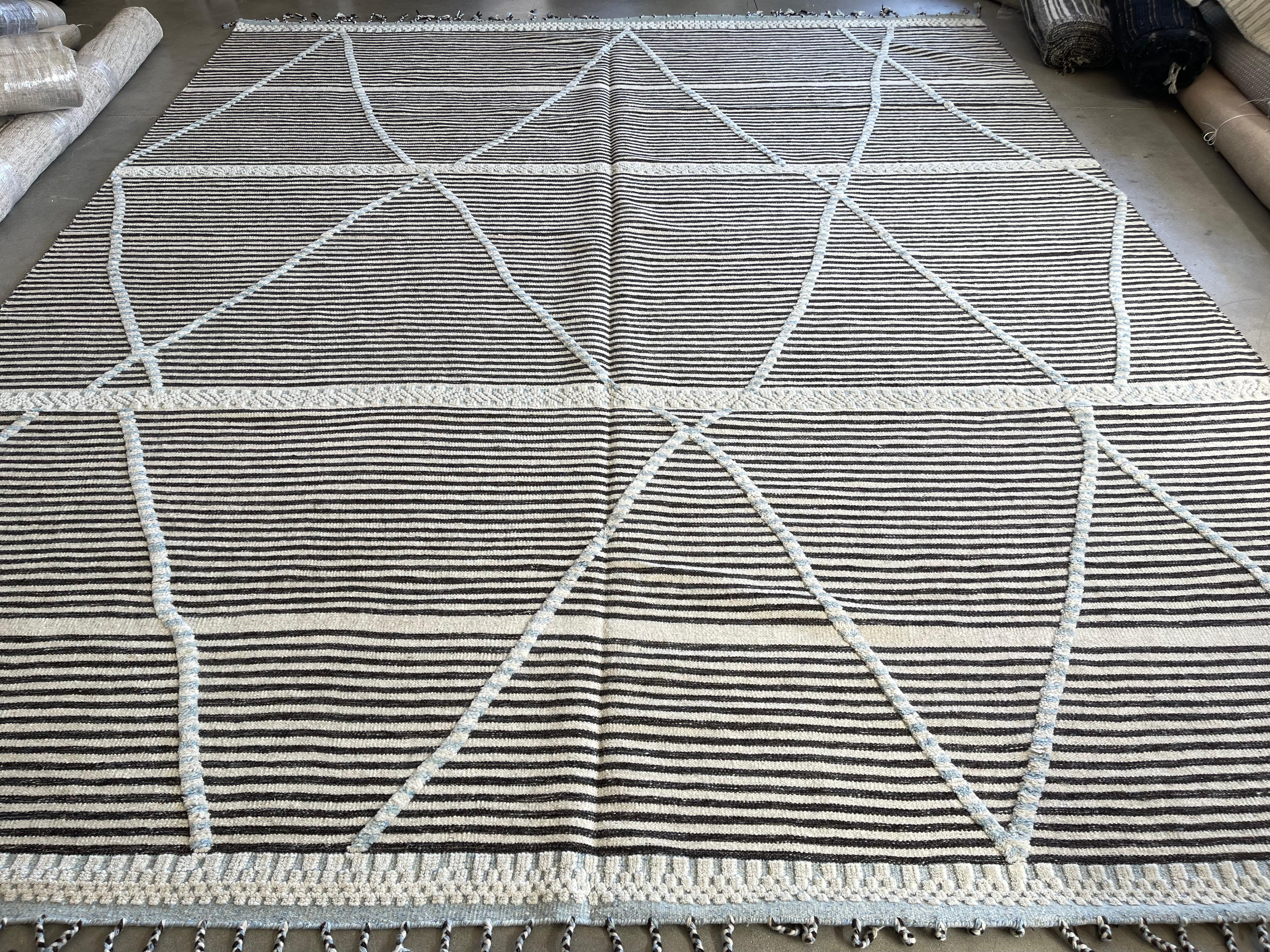 Questo tappeto oversize con combinazione di colori e design marocchino, appartenente alla nostra nuovissima collezione di disegni marocchini, è fatto a mano e annodato a mano in India. Ha una base di cotone ed è realizzato con filati di lana.