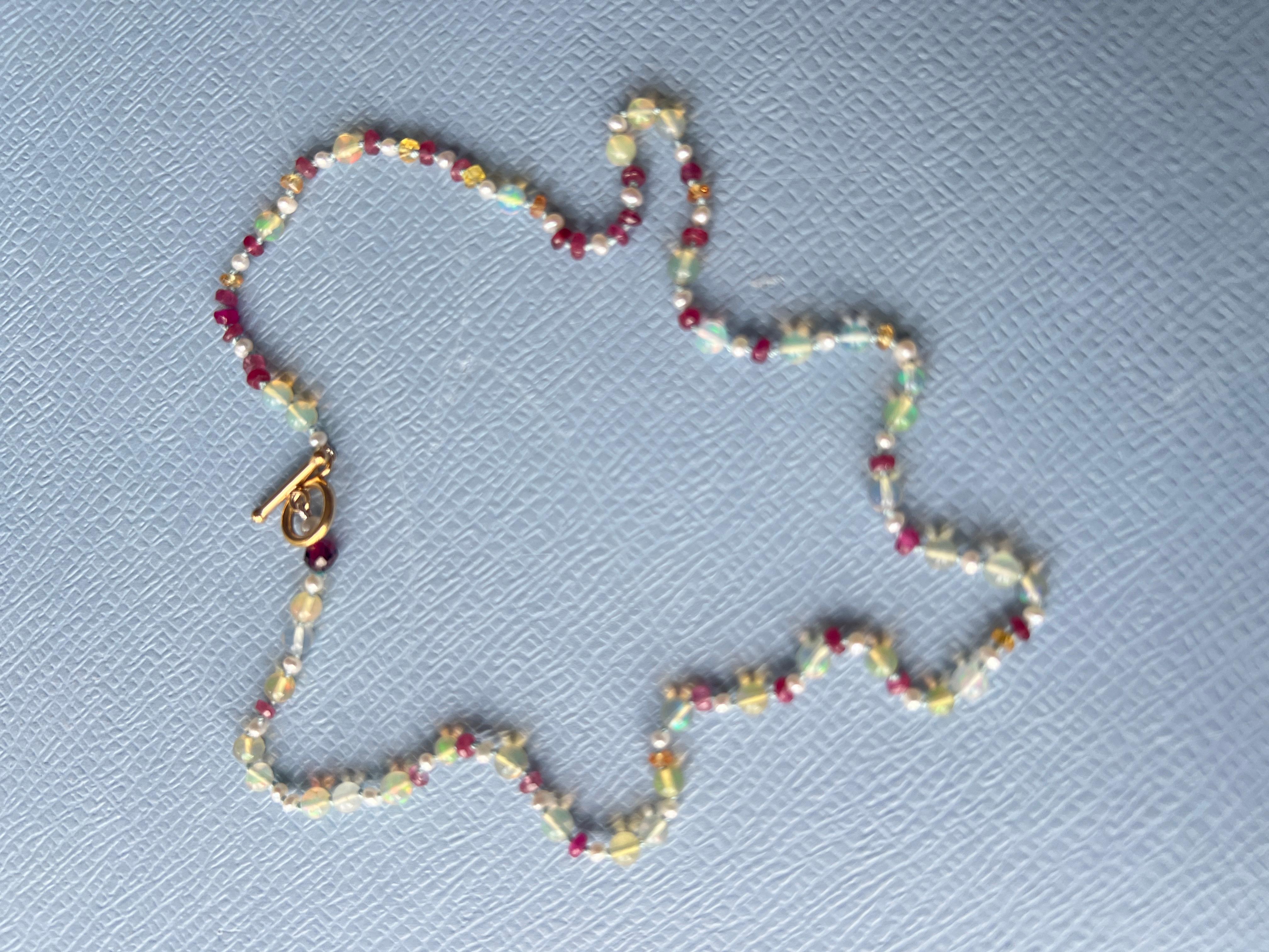 Multi Colored Opal Ruby Pearl Bead Choker Necklace with a gold filled clasp

The choker features a combination of rubies, opals, and white pearls, each chosen for both their aesthetic qualities and traditional meanings. Rubies are valued for their