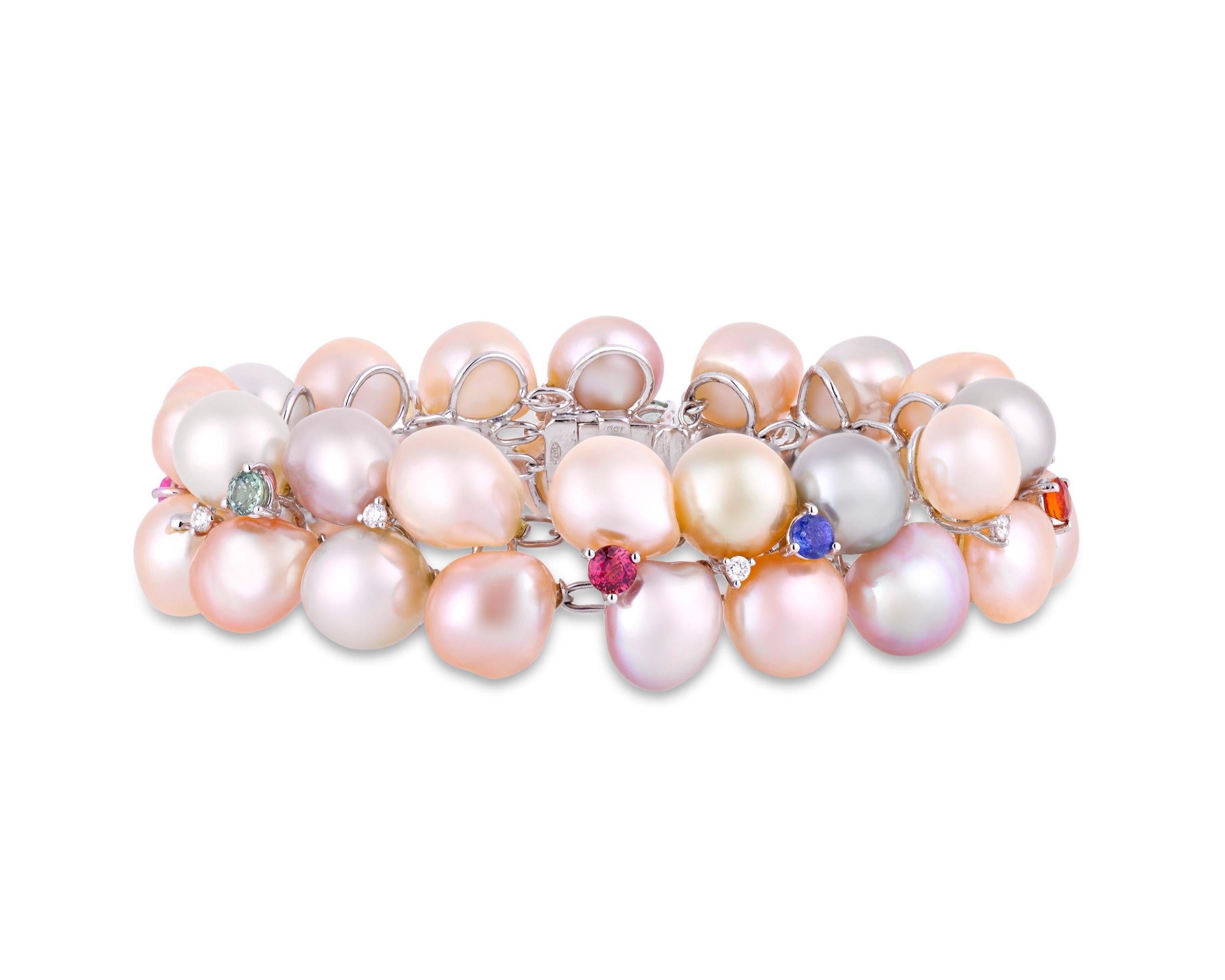 At once chic and playful, this bracelet features a collection of lustrous baroque pearls. Ranging in color from light pink to mauve, the pearls are joined by white diamonds totaling 0.31 carat and fancy colored sapphires in a rainbow of hues