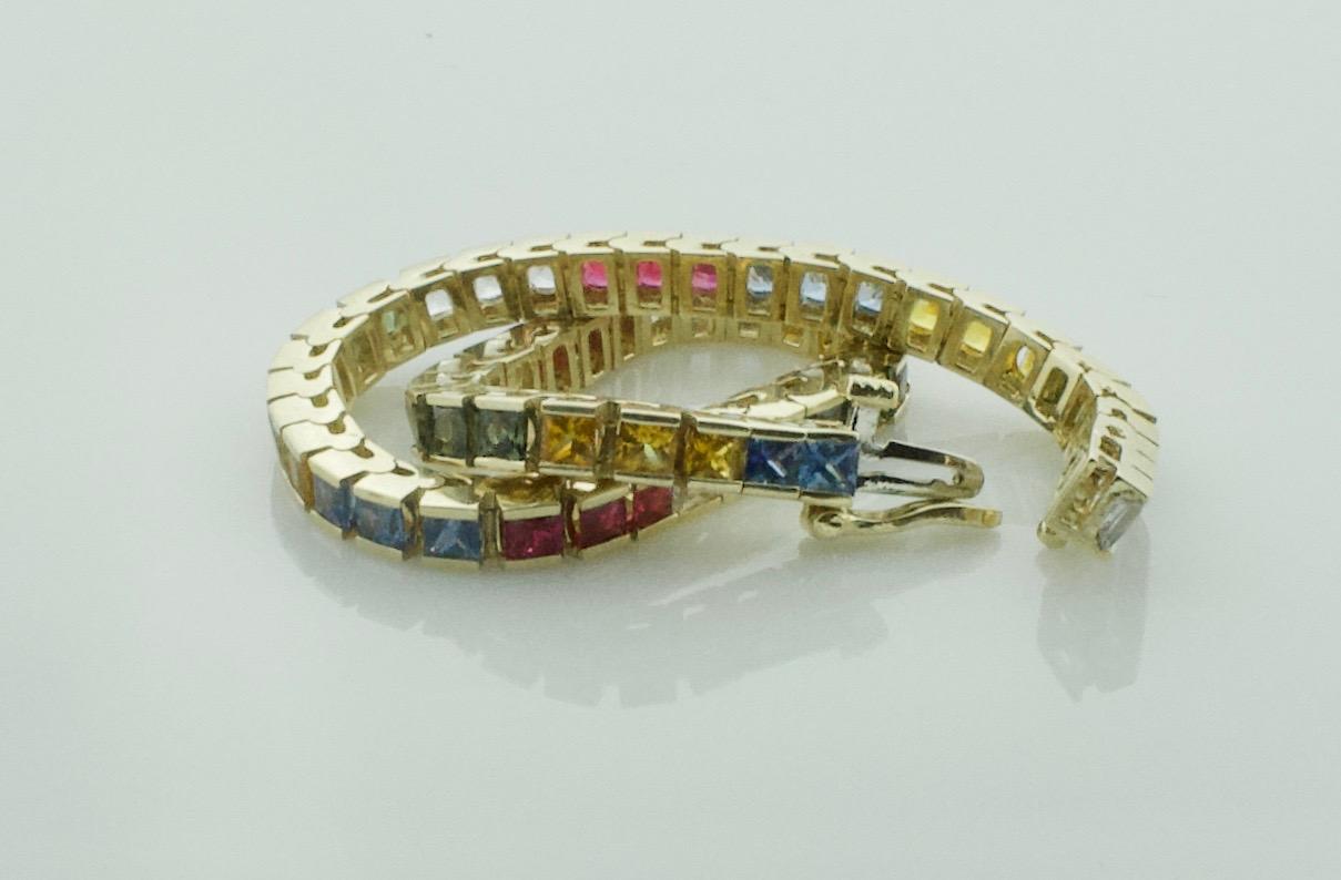 Princess Cut Multicolored Sapphire and Ruby Tennis Bracelet in Yellow Gold For Sale