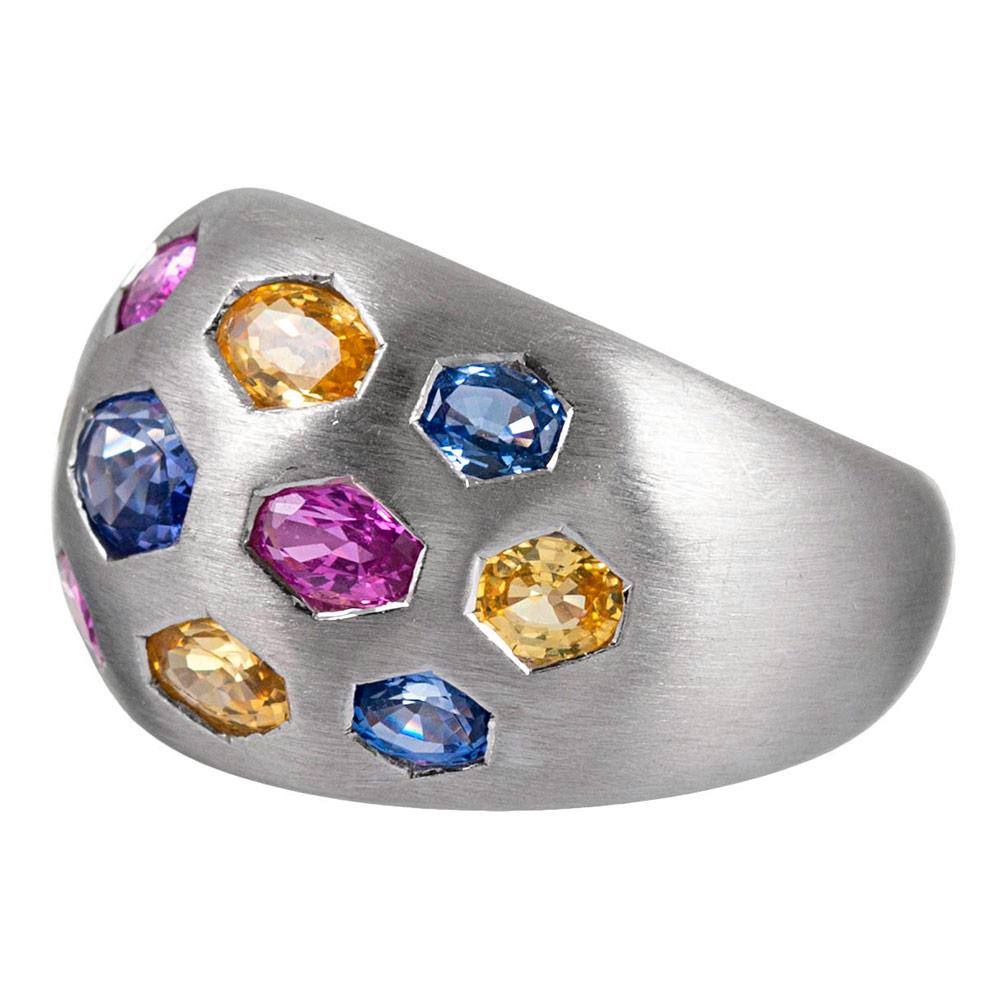 Satin-finished 18 karat white gold displays oval faceted sapphires of blues, pinks and yellows in hexagonal bezels. This piece is unusual and beautiful with the ideal balance of playfulness and sophistication. The sapphires weigh 3.78 carats in