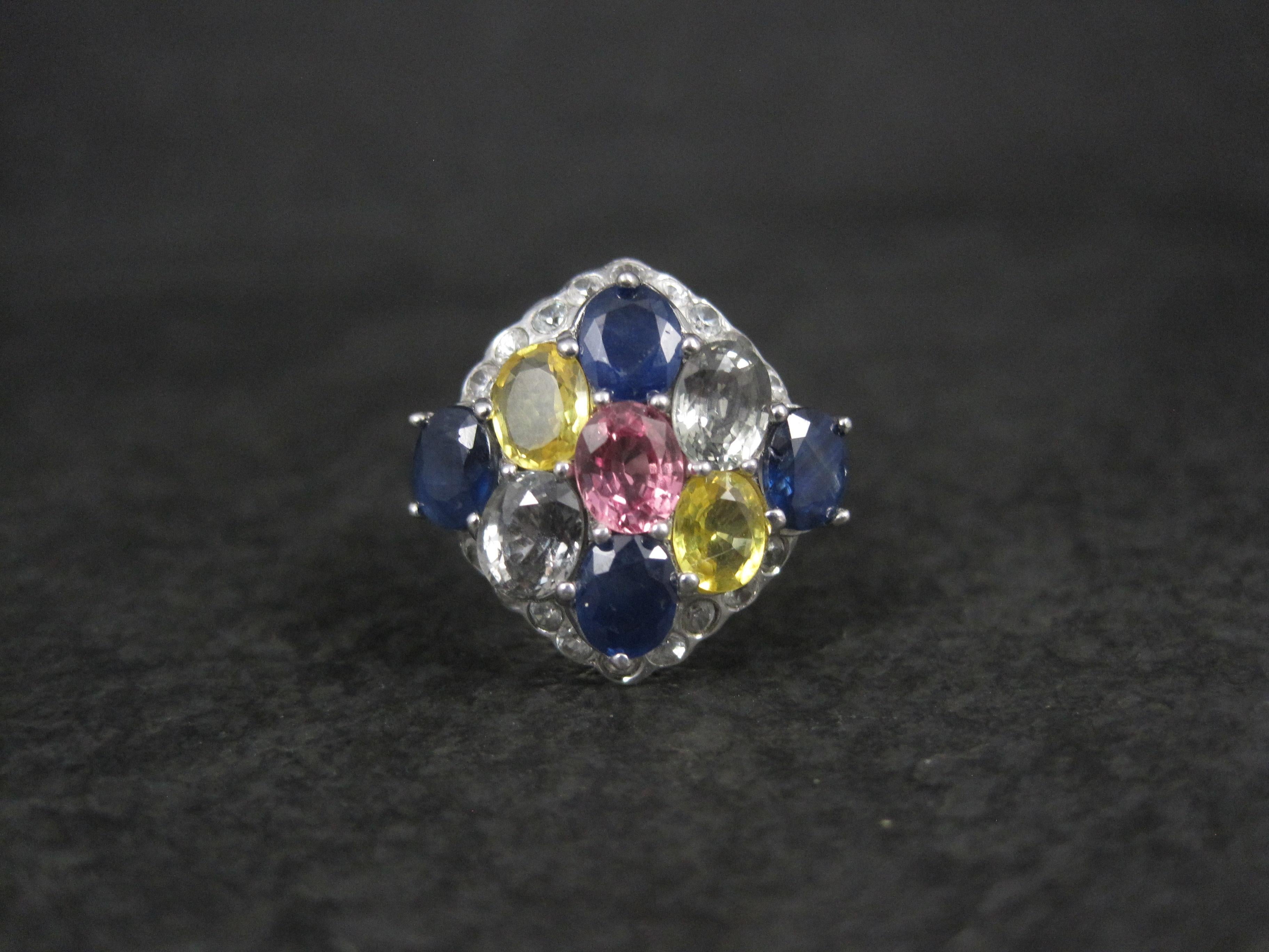 Questo splendido anello è in argento sterling.
Presenta una combinazione di zaffiri blu, verdi, gialli e rosa accentuati da uno spinello bianco.
Il peso totale è stimato in 5 carati.

La faccia di questo anello misura 11/16 di pollice da nord a