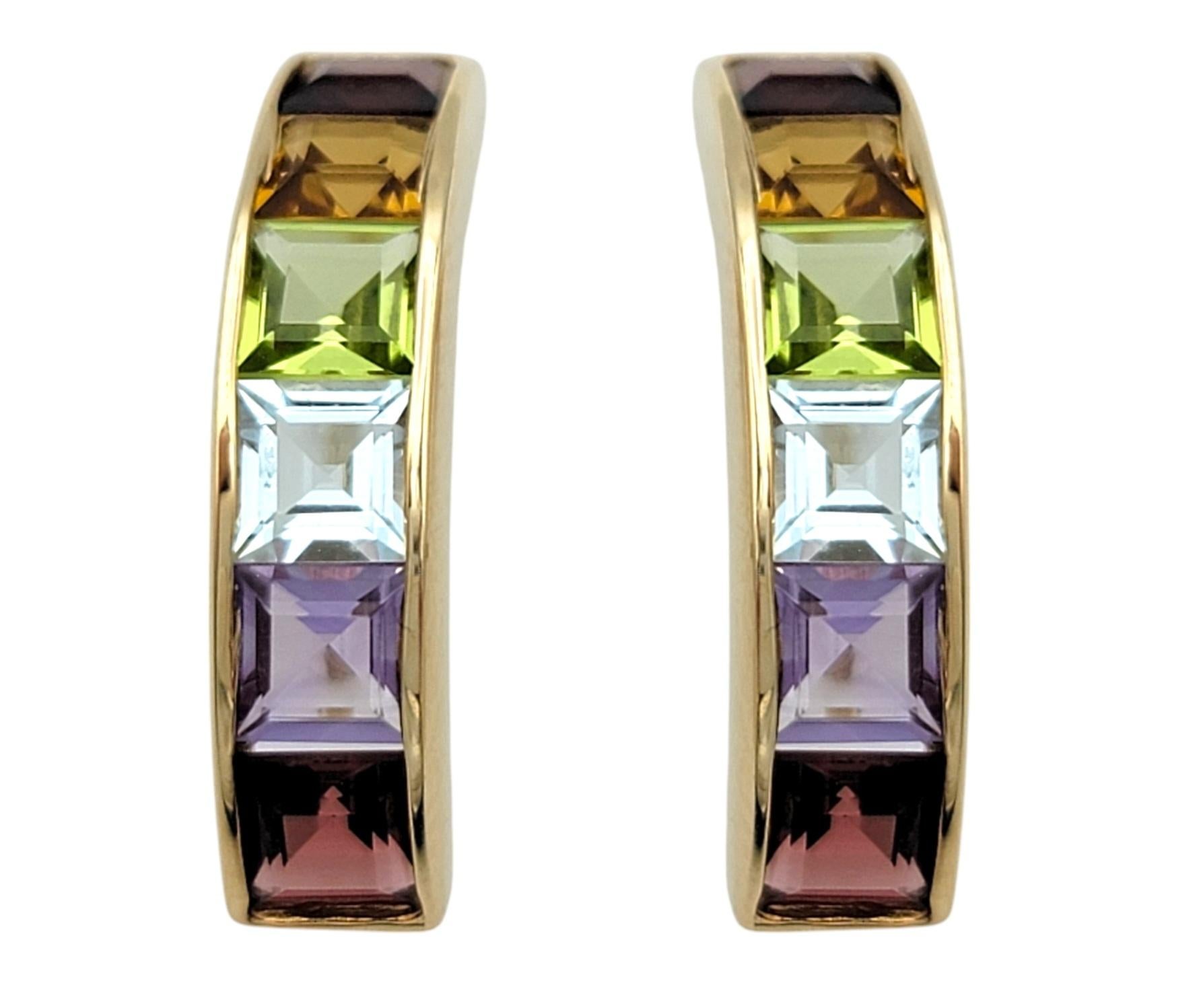 Add a vibrant splash of color to your jewelry collection with these stunning rainbow J-hoop stud earrings, crafted in luxurious 14 karat yellow gold. Each earring is adorned with a dazzling array of multi-colored gemstones, including rich red
