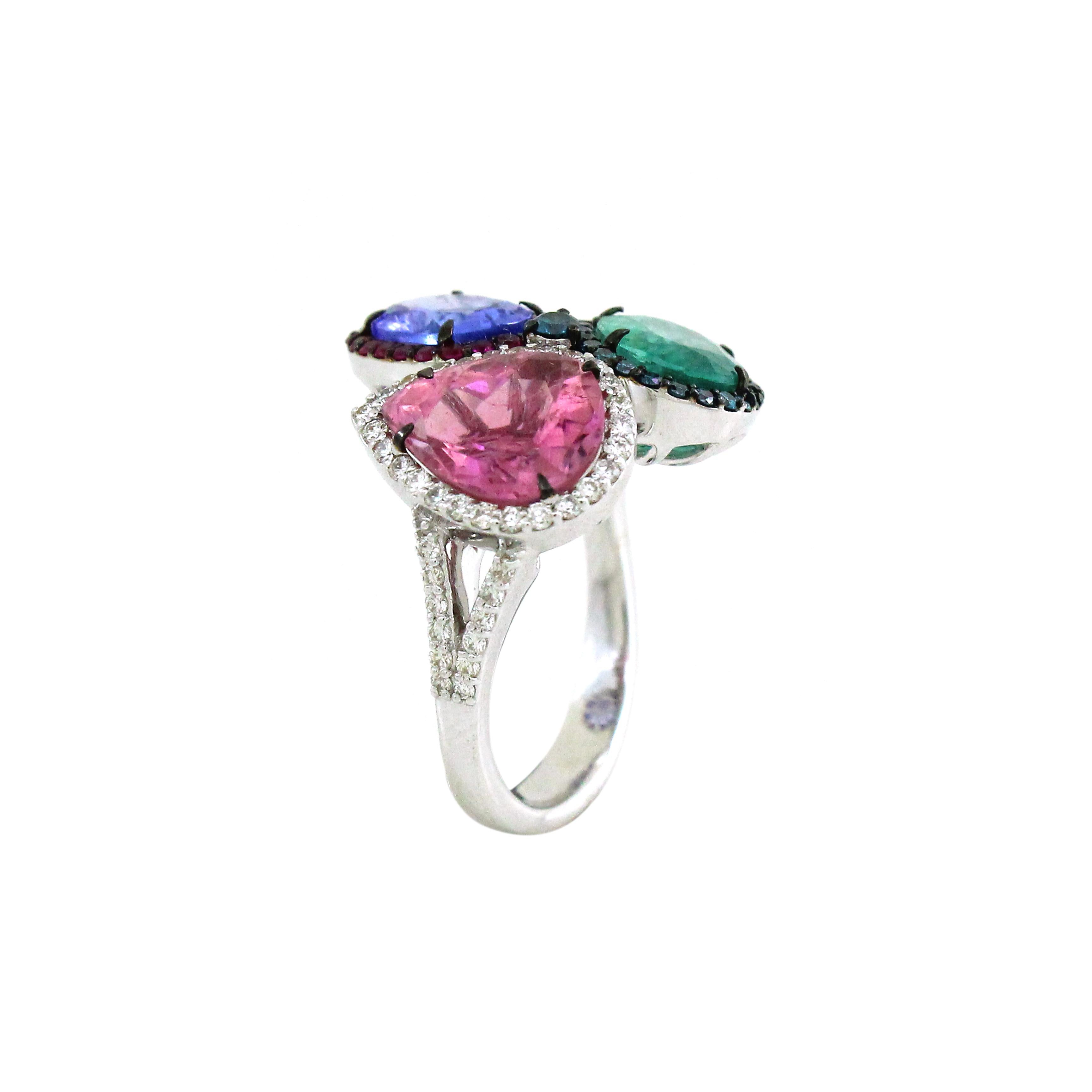 Elegance and extravagance intertwine in this mesmerizing three-stone ring. At its heart, a tantalizing 1.59-carat oval-cut tanzanite exudes a deep blue-violet hue, its brilliance amplified by a dazzling halo of 22 round rubies, each 0.19 carats.